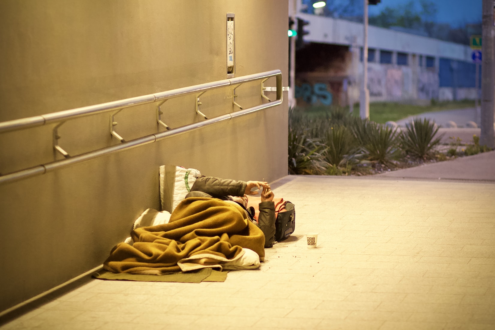 Homeless person sleeping on sidewalk