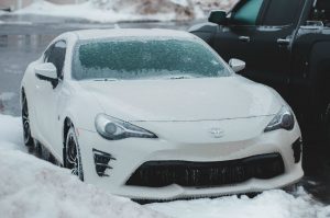 White car surrounded by snow with icy windshield; image by Erik Mclean, via Unsplash.com.