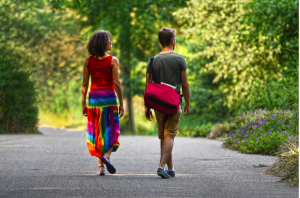 Man and woman walking down road; image by Mabel Amber, via Pixabay.com.