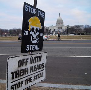 Roadside protest sign near the Capitol building. It says, "Stop the Steal" and "Off with their heads."