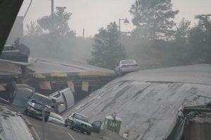 Concrete slabs tilt at odd angles with cars in disarray.