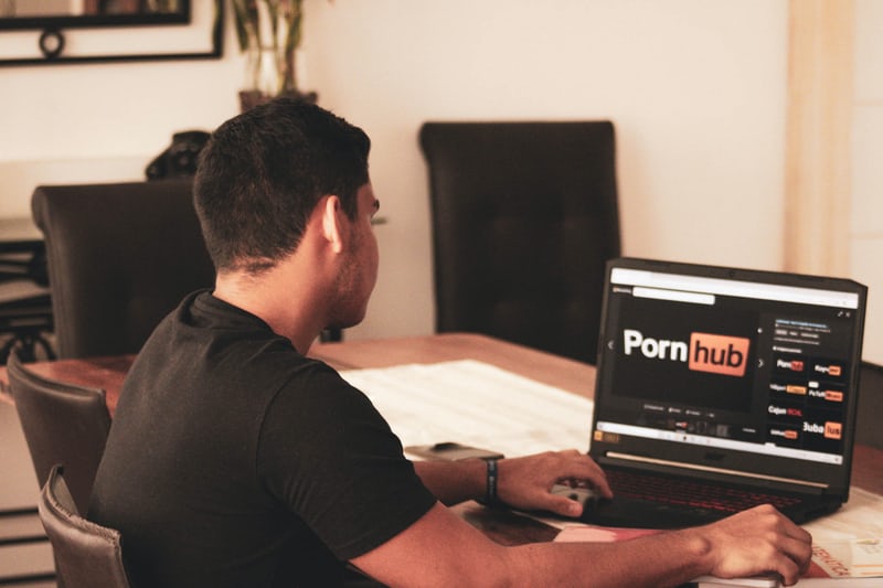 Person at computer with Pornhub Website on screen