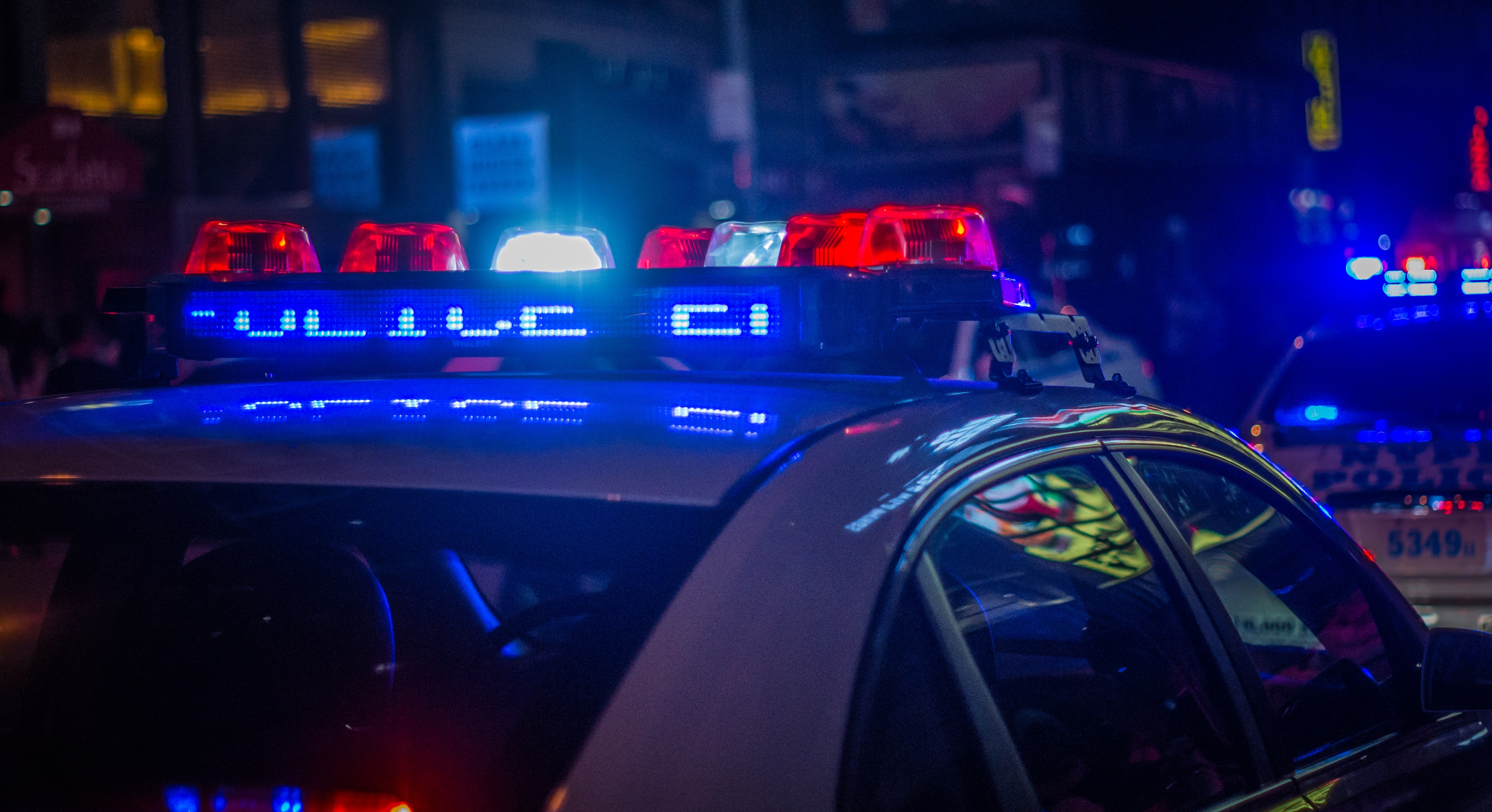 The red and blue flashing lights from a police cruiser in the darkness.