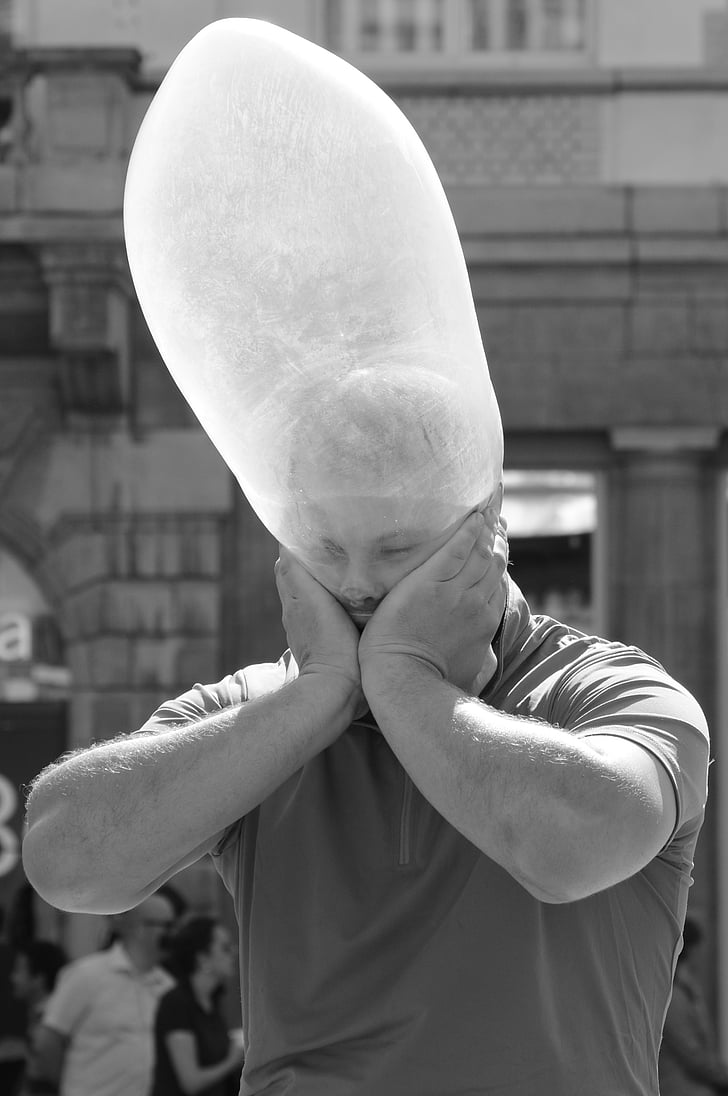 A man with an inflated condom on his head.