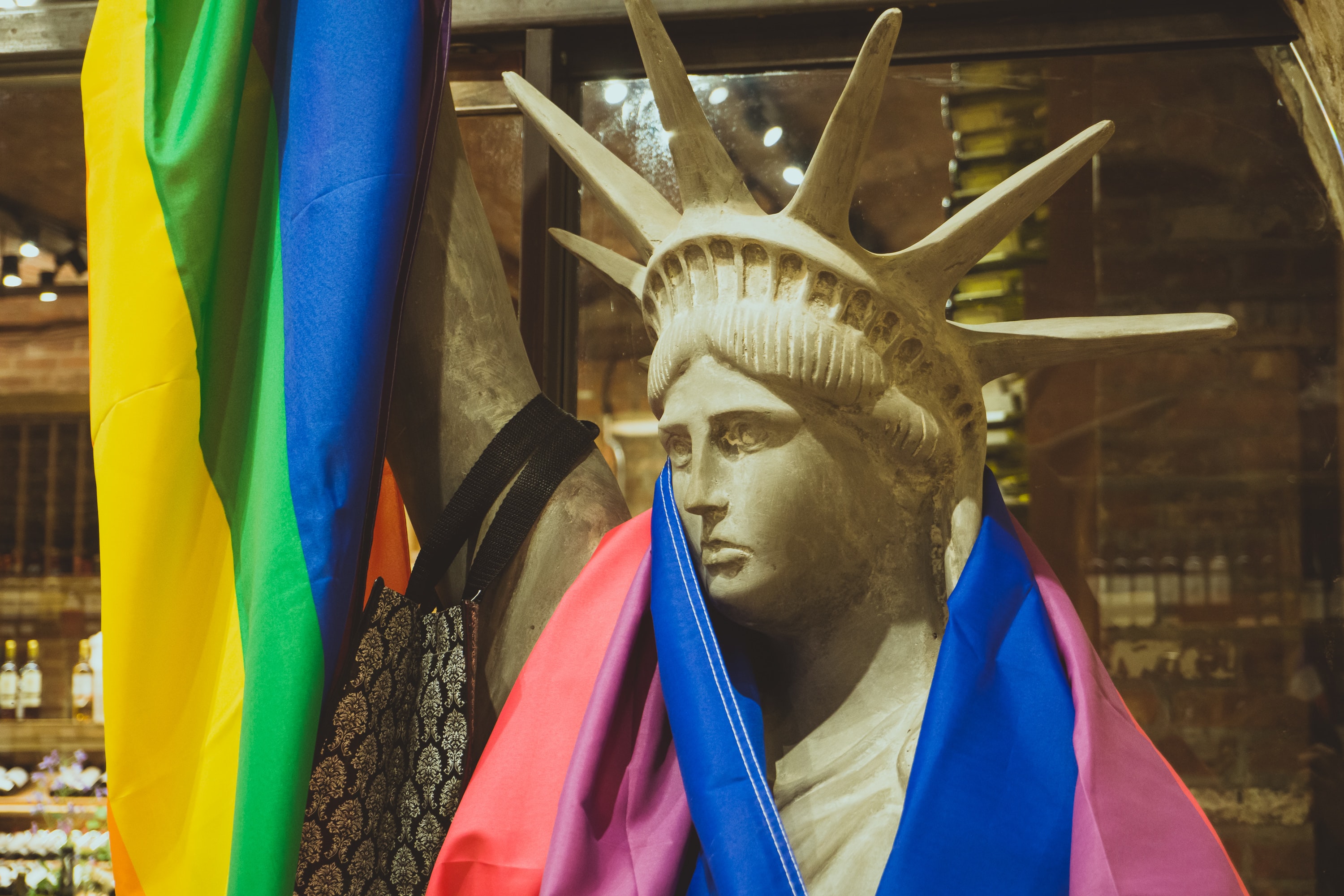 A Lady Liberty sculpture draped with the Rainbow flag.
