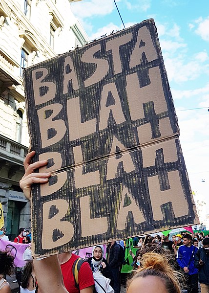 A cardboard sign lofted by a protester reads, "Basta Blah Blah Blah."