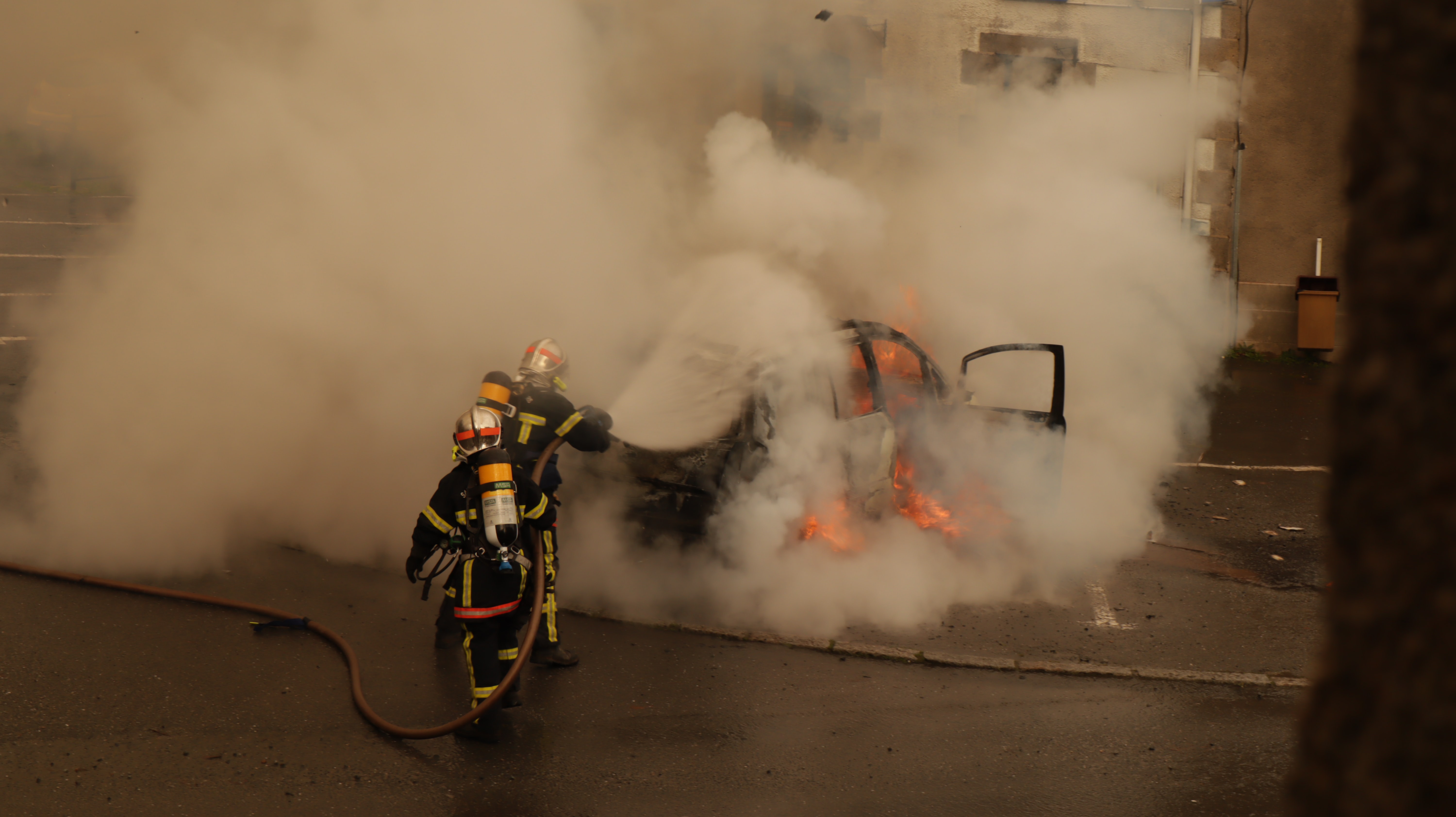FIrefighters putting out vehicle fire; image by Gwendal Bar, via Unsplash.com.