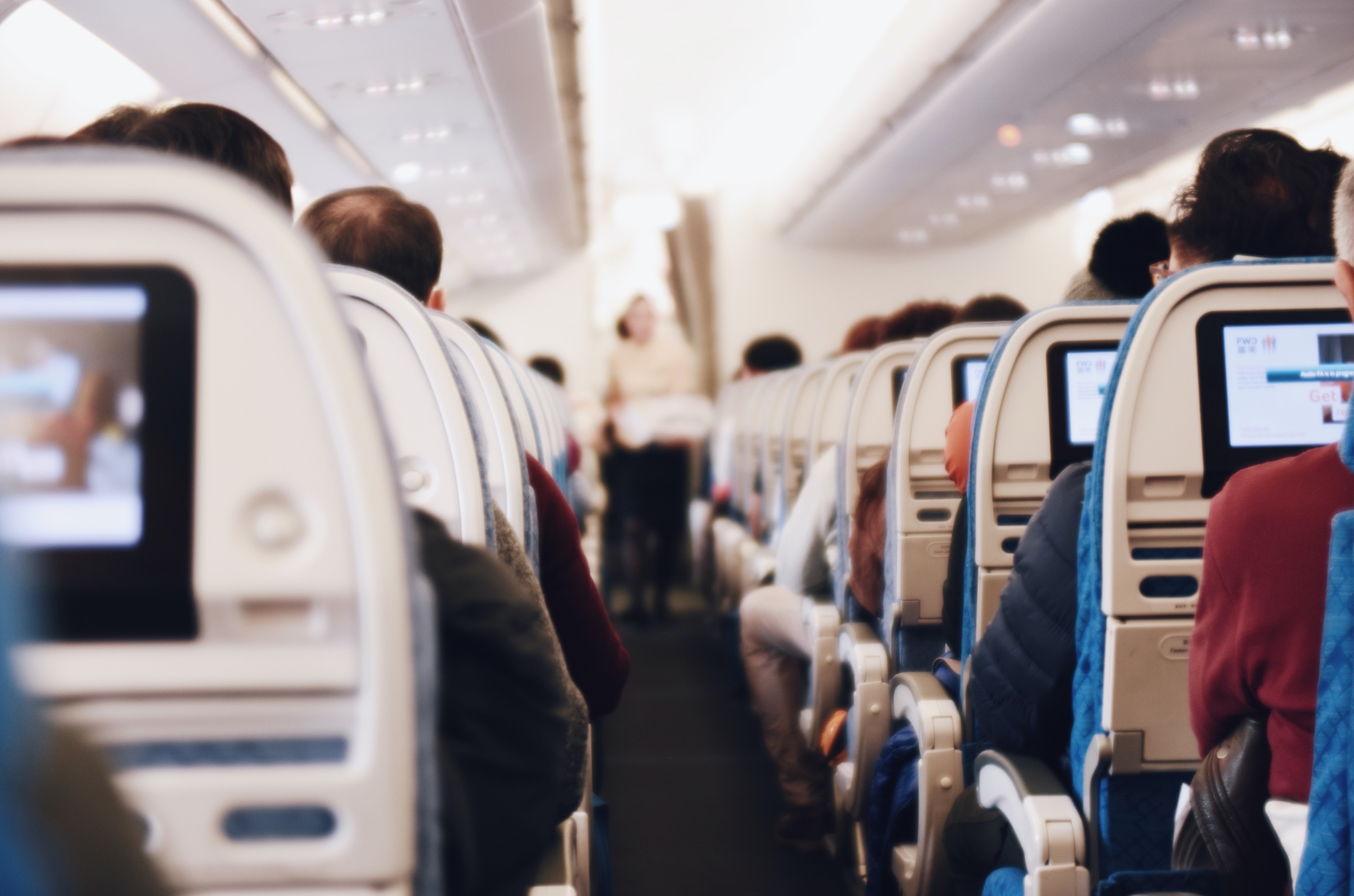 Rearview of passengers on a plane; image by Suhyeon Choi, via Unsplash.com.