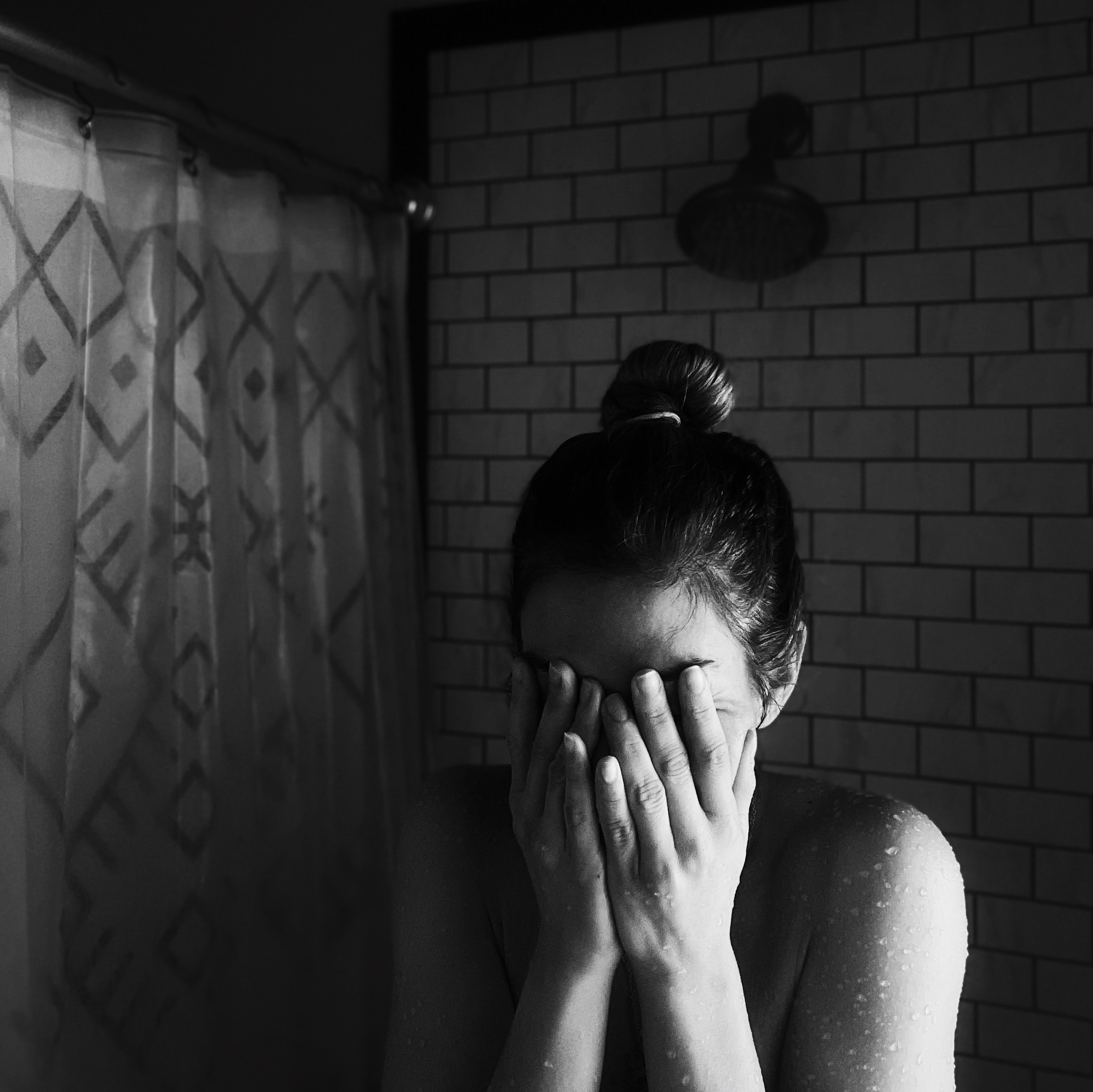 Sad woman in shower; image by Meghan Hessler, via Unsplash.com.
