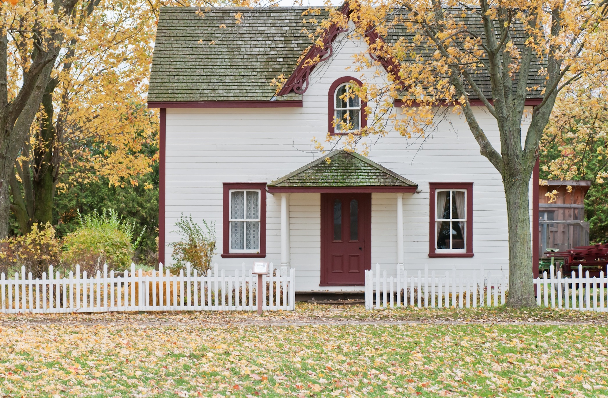 White house under maple trees in autumn; image by Scott Webb, via Unsplash.com.