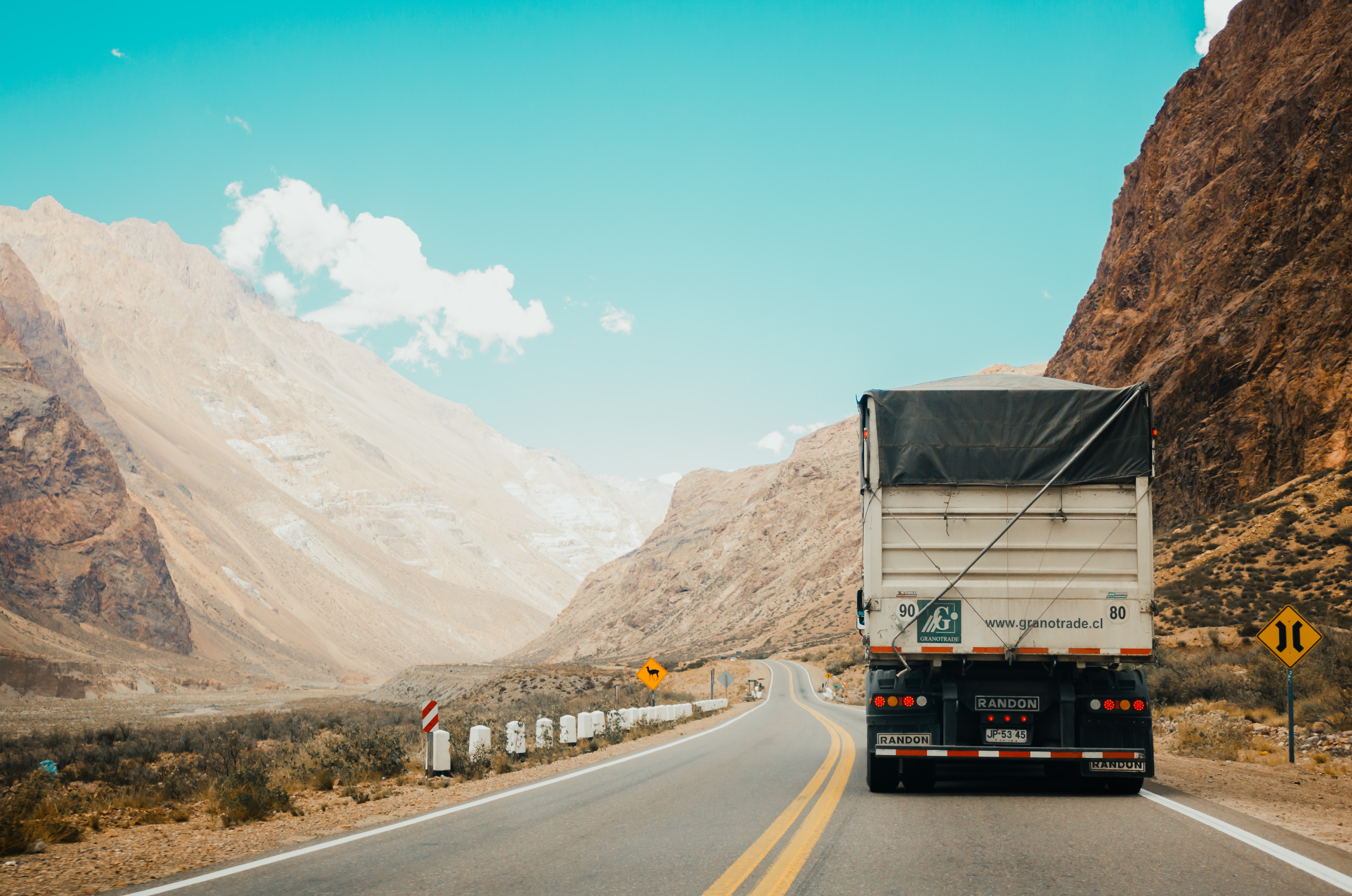Dump truck on the road in the mountains; image by Rodrigo Abreu, via Unsplash.com.
