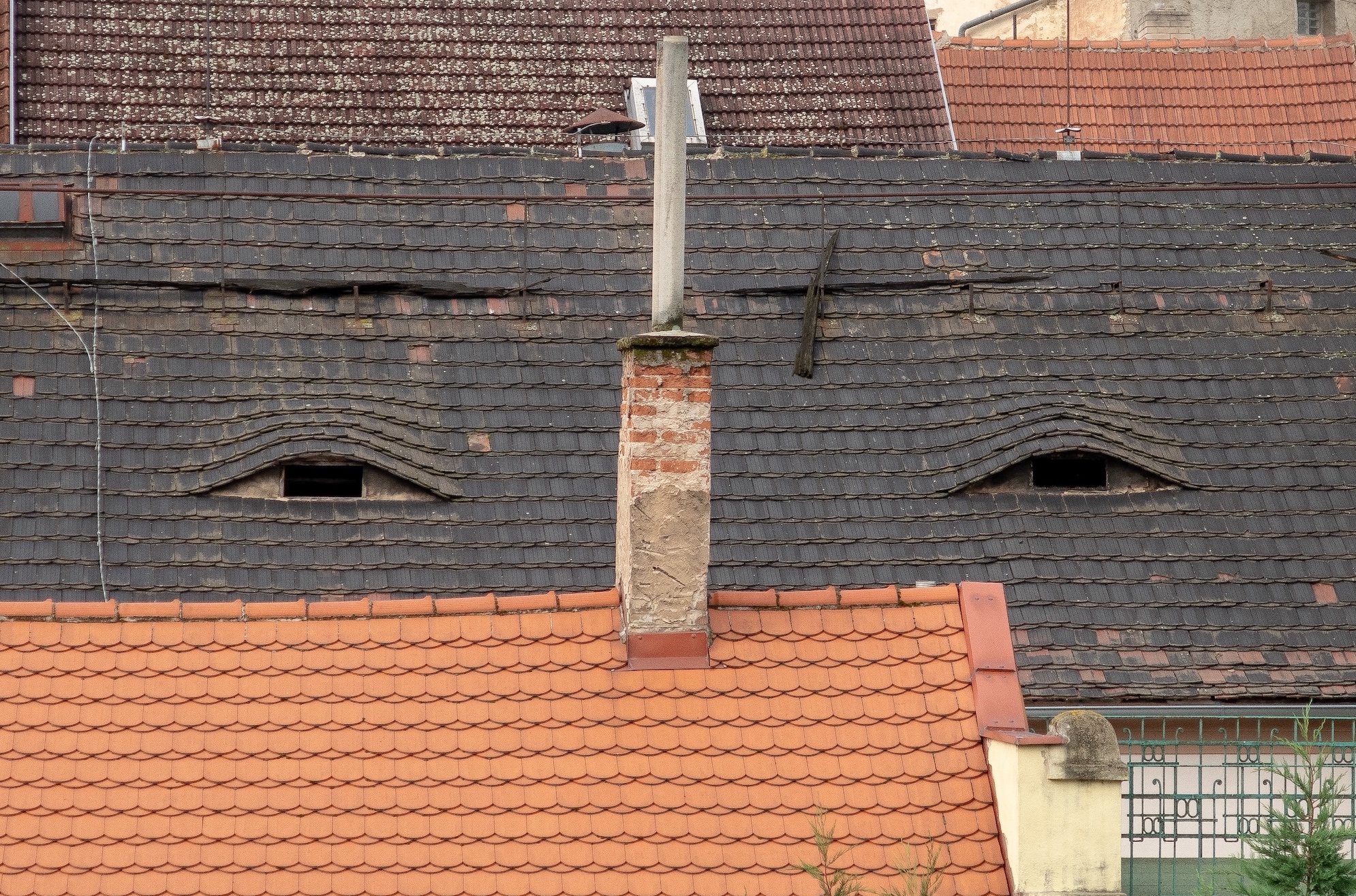 House with roof damage and windows that look like eyes; image by Martin Krchnacek, via Unsplash.com.