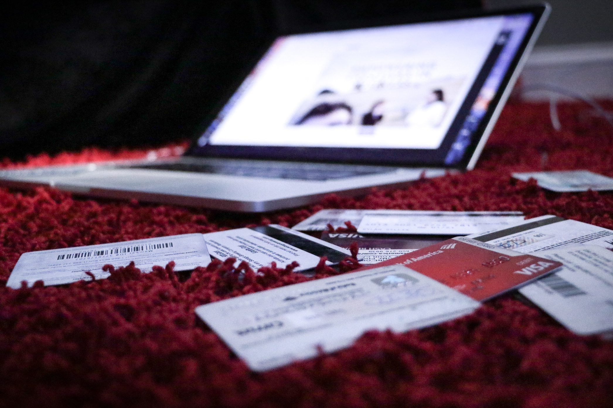 Laptop and credit cards on red shag carpet; image by Dylan Gillis, via Unsplash.com.