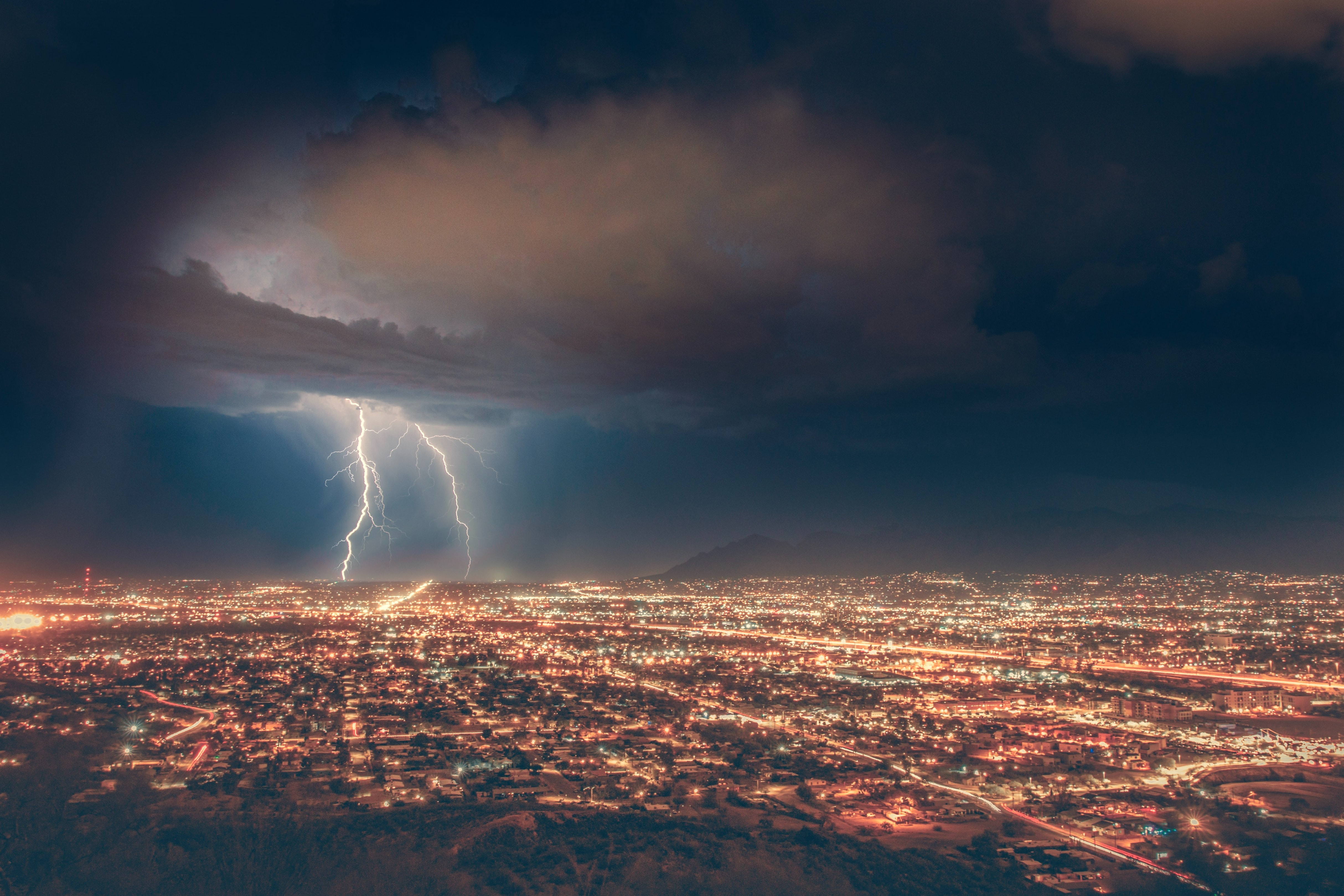 Lightning over large city; image by Michael D, via Unsplash.com.