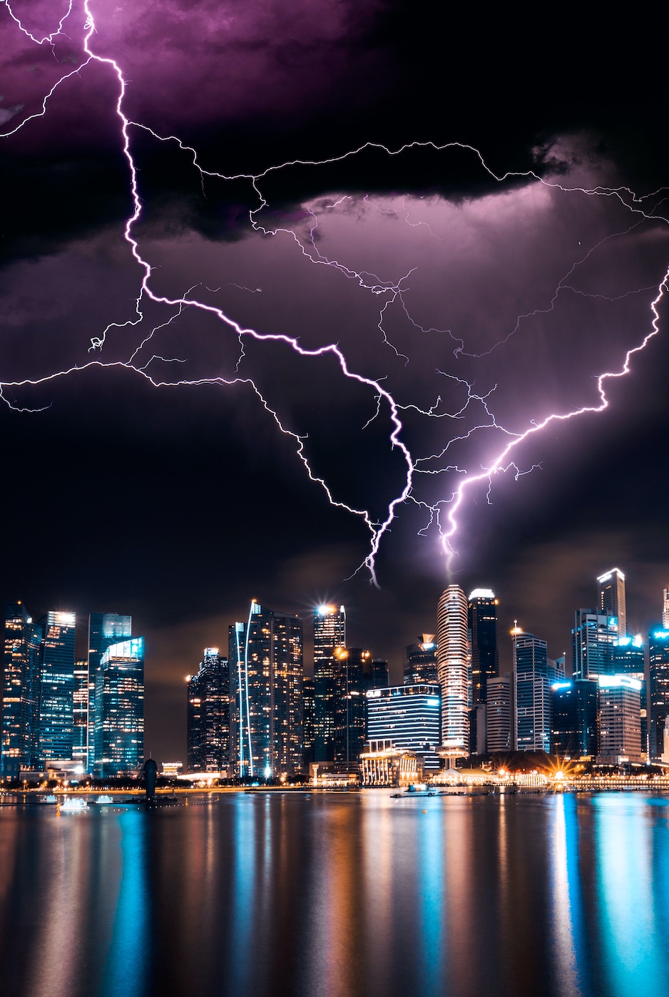 Lightning strikes over city; image by Lee Junda, via Unsplash.com.