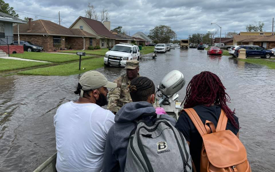 Louisiana National Guardsman in rescue boat with rescued family, after Hurricane Ida, Laplace, LA;.image by The National Guard, via Flickr, CC BY 2.0.