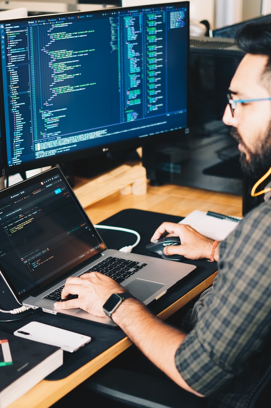 Man using laptop and large monitor; image by Procreator UX Design Studio, via Unsplash.com.