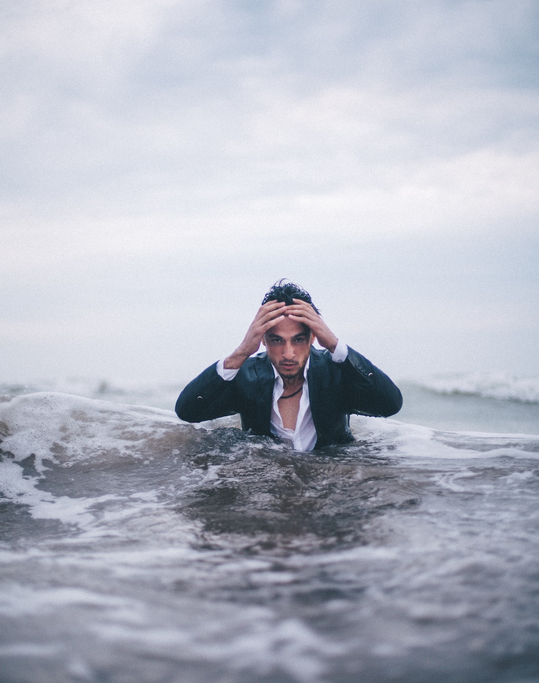 Overwhelmed man waist-high in water; image by Mubariz Mehdizadeh, via Unsplash.com