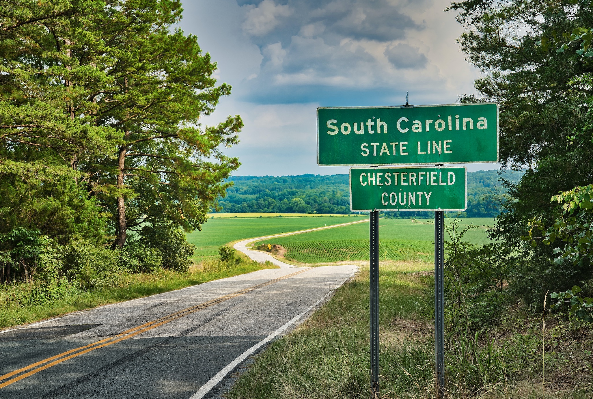 Road with sign saying, South Carolina State Line, Chesterfield County; image by Clint Patterson, via Unsplash.com.
