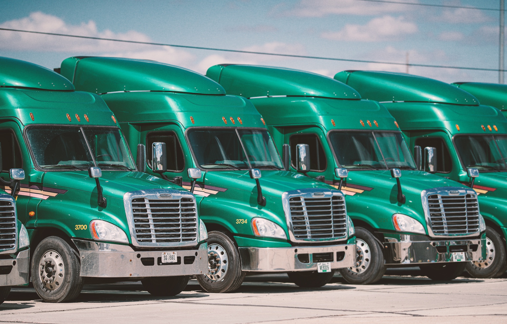 Row of green trucks; image by Brian Stalter, via Unsplash.com.