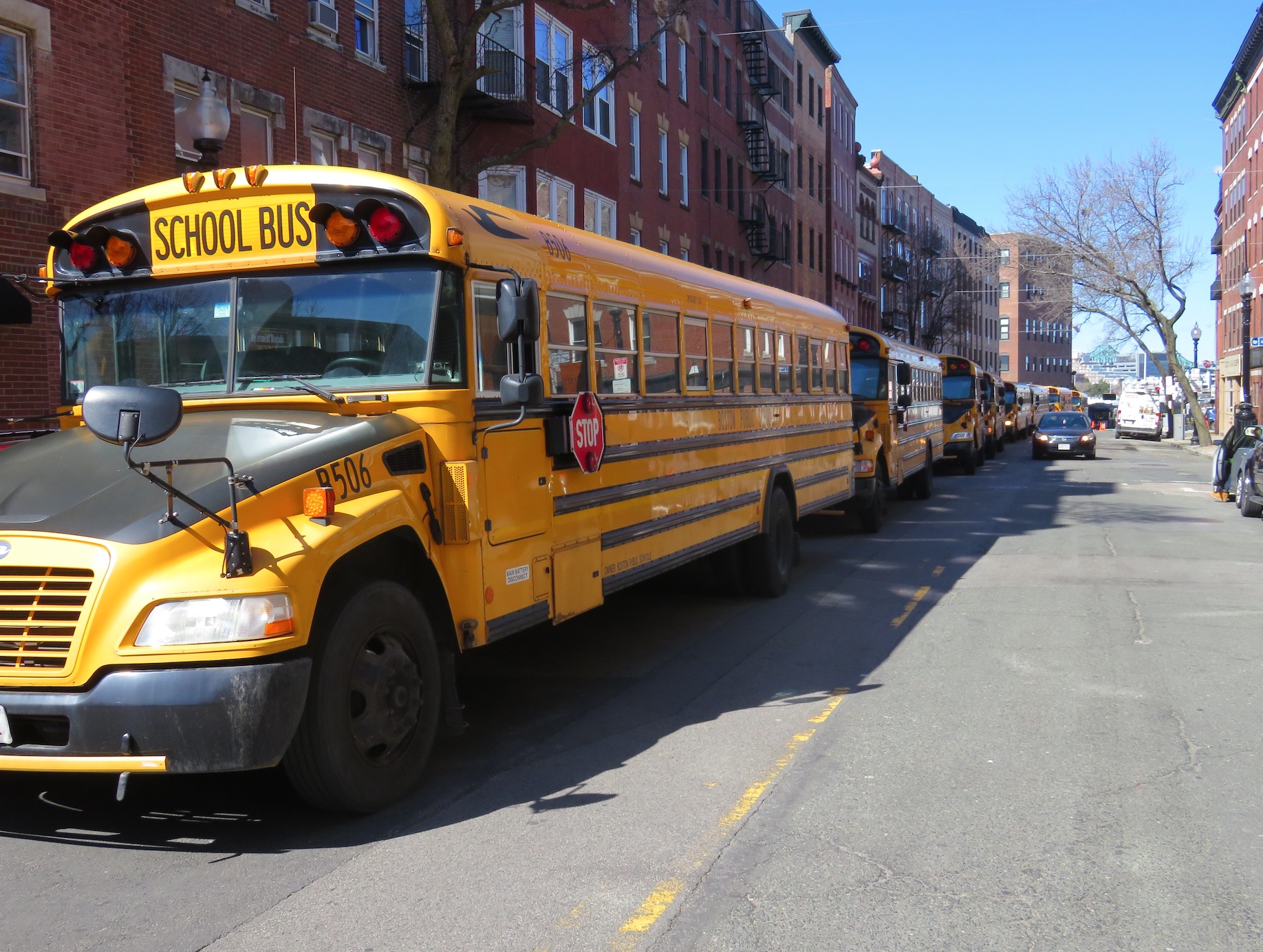School busses lining the street; image by Darran Shelton, via Unsplash.com.