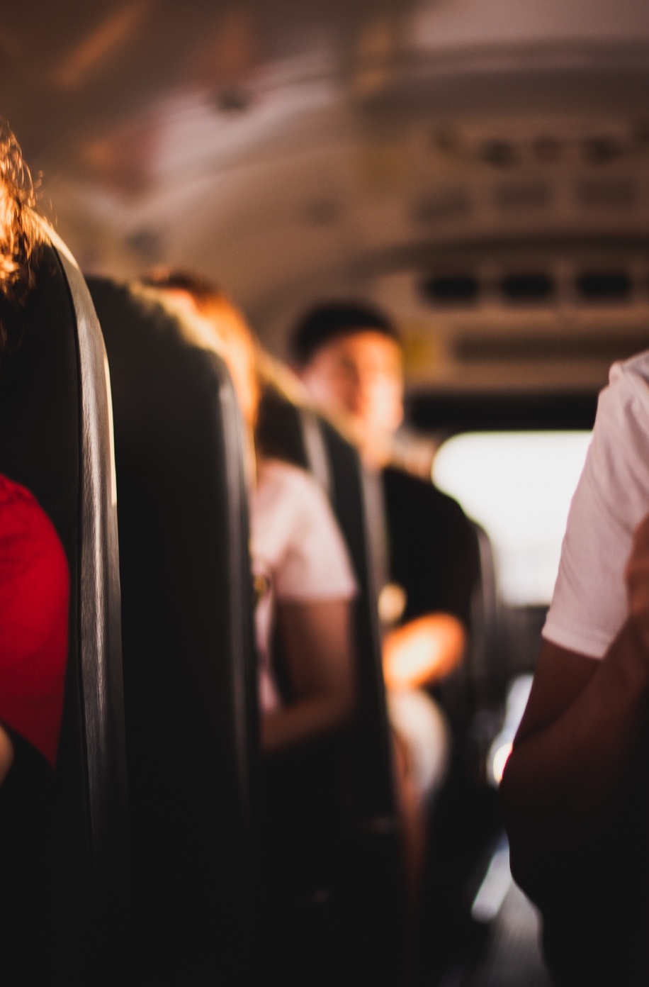 Soft-focus shot of kids on school bus; image by Jeswin Thomas, via Unsplash.com.