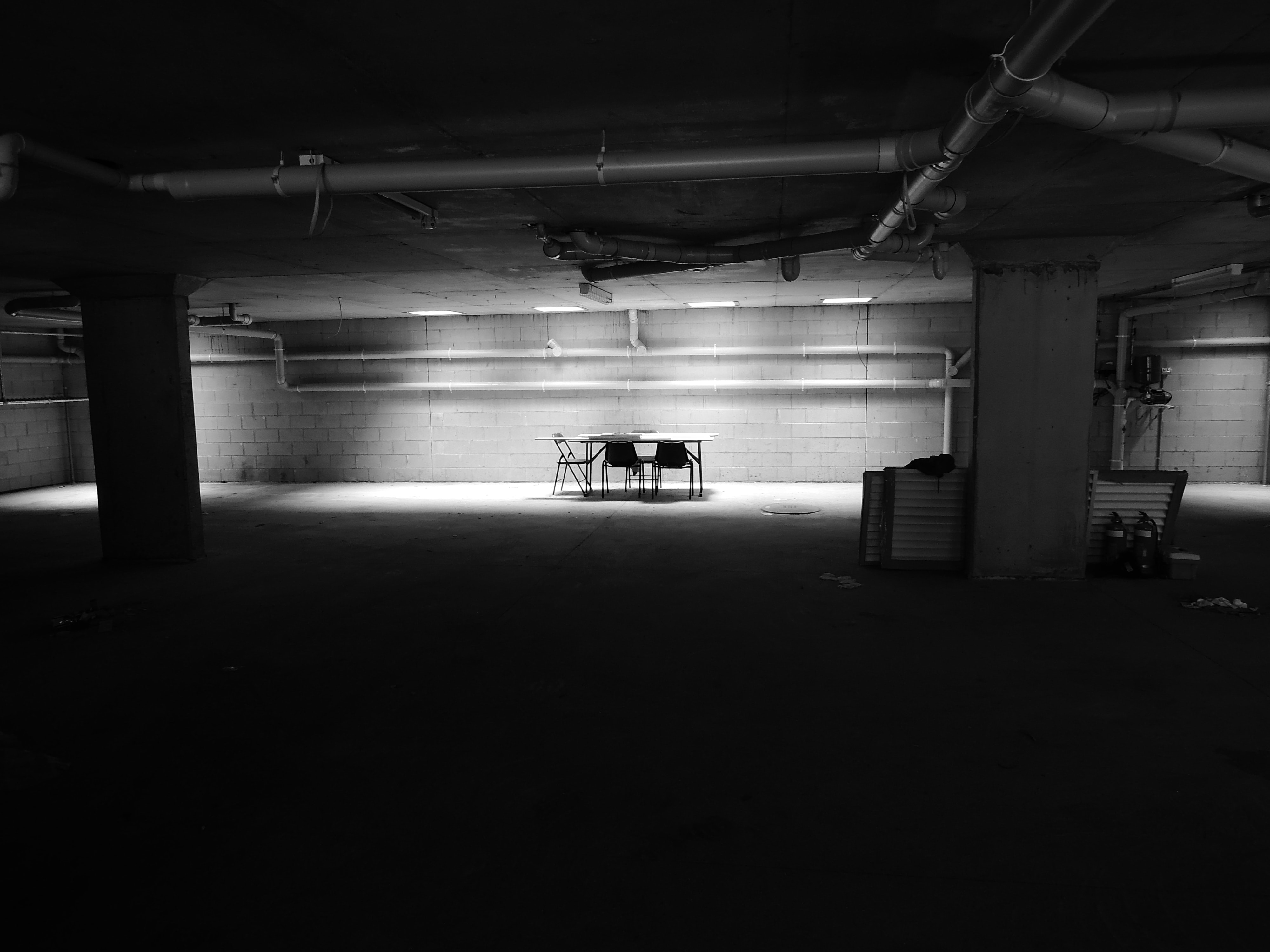 Table and chairs in dark room; image by Jonny Clow, via Unsplash.com.