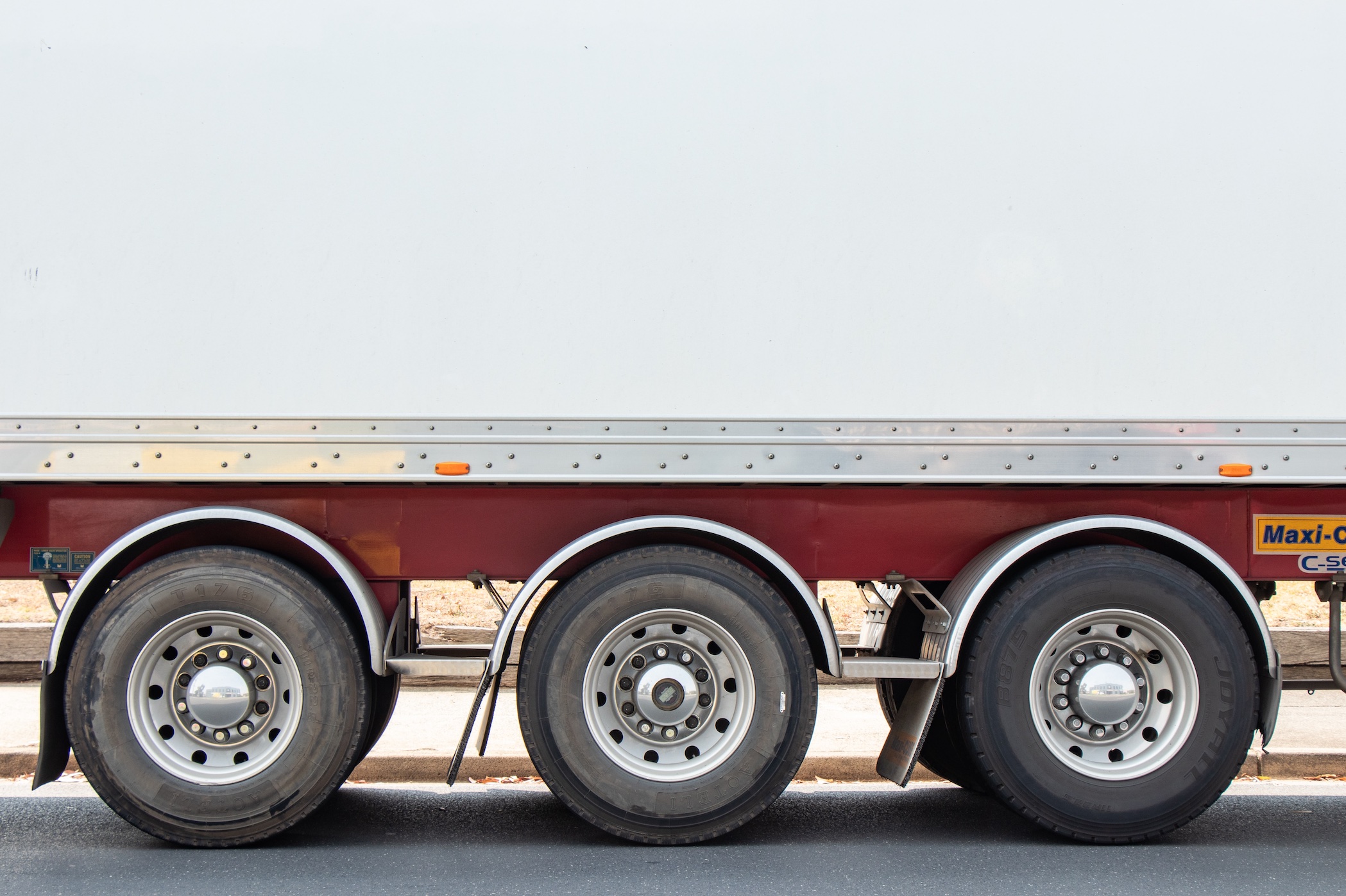 Upclose shot of semi-truck tires; image by Mitchell Luo, via Unsplash.com.