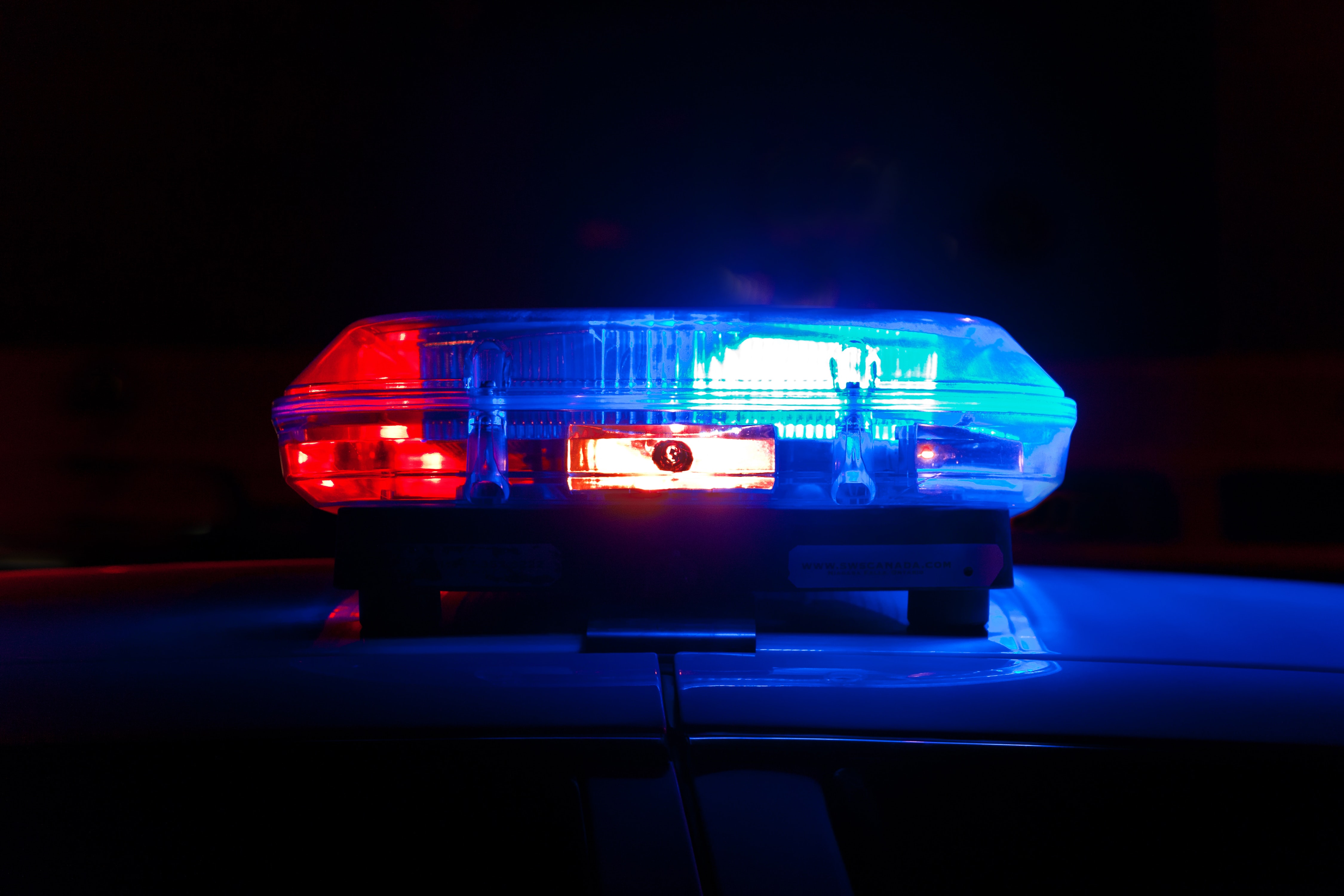 Blue and red police lights; image by Scott Rodgerson, via Unsplash.com.
