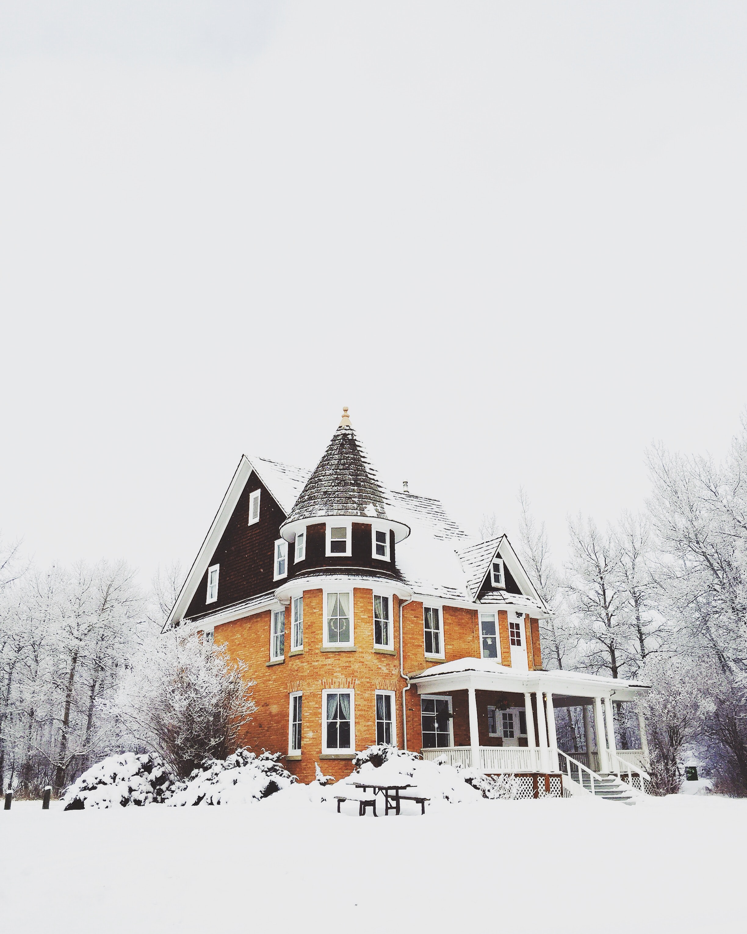 Stately home under snow; image by Nathan Walker, via Unsplash.com.