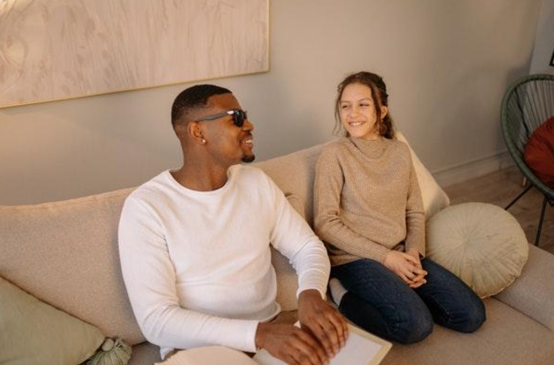 Woman talking with blind man; image by Yan Krukov via Pexels.com.