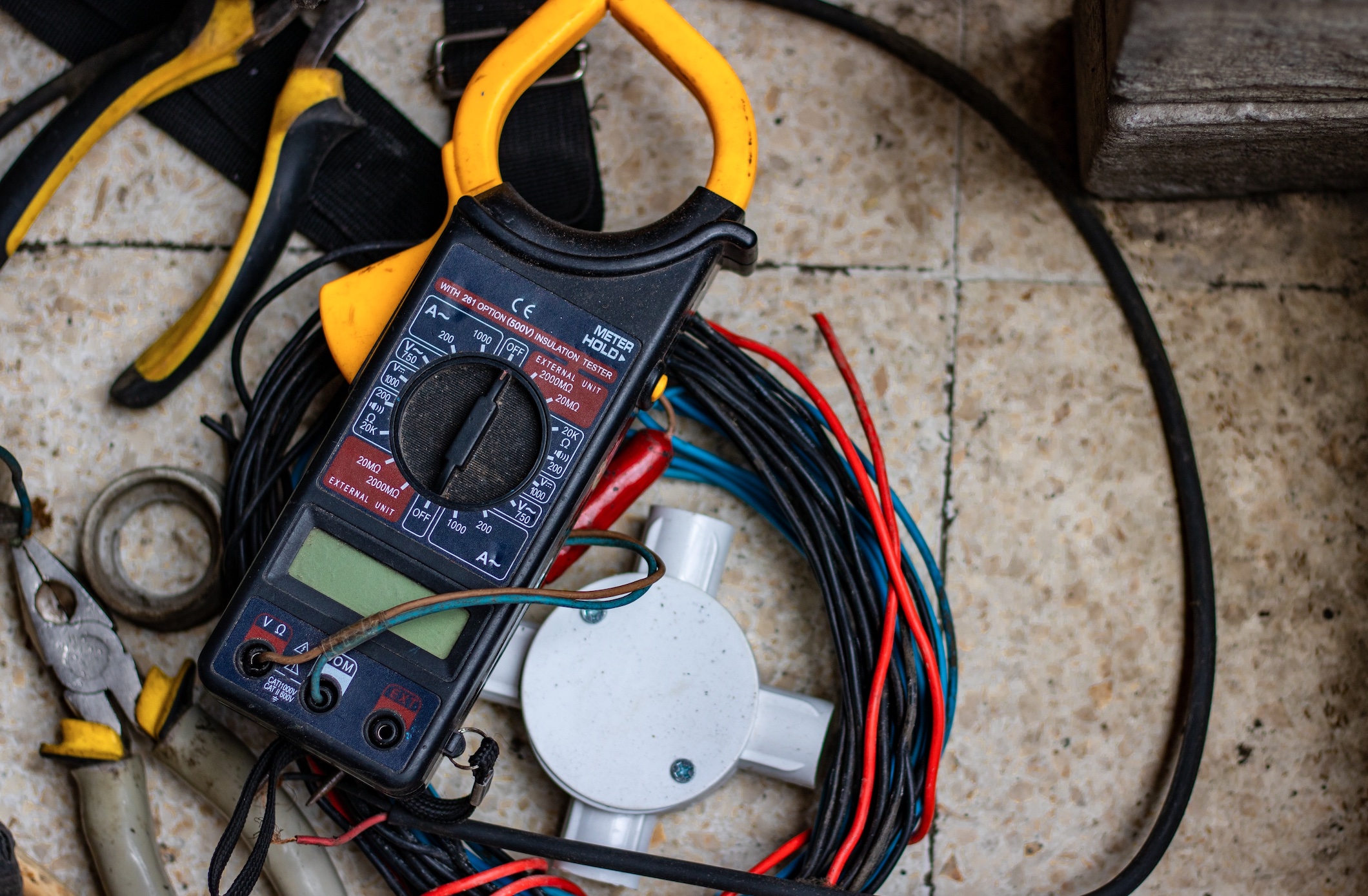 Electric clamp meter and wires; image by Hobi Industri, via Unsplash.com.