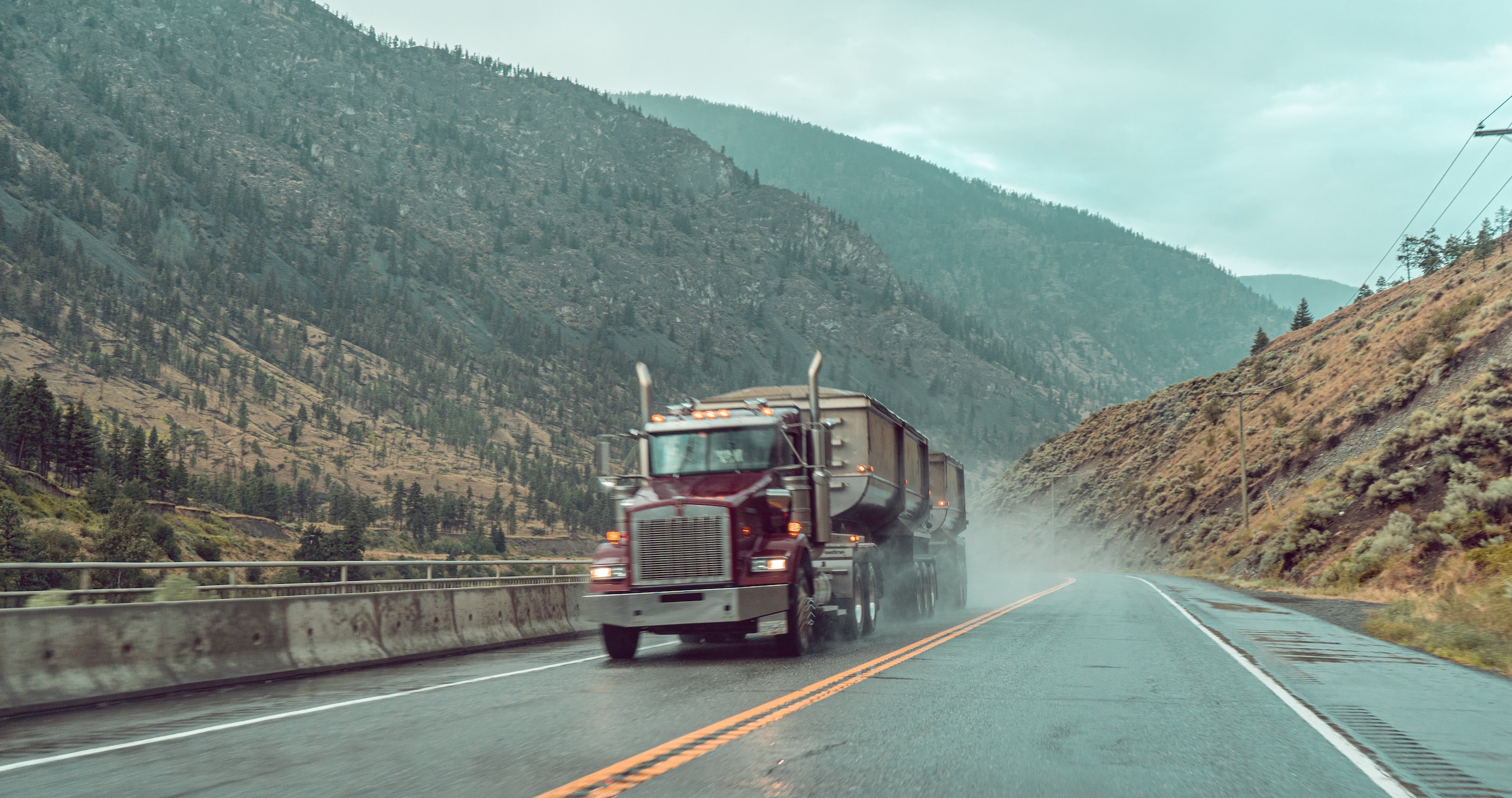 Gravel truck on wet road; image by Daniel Prado, via Unsplash.com.