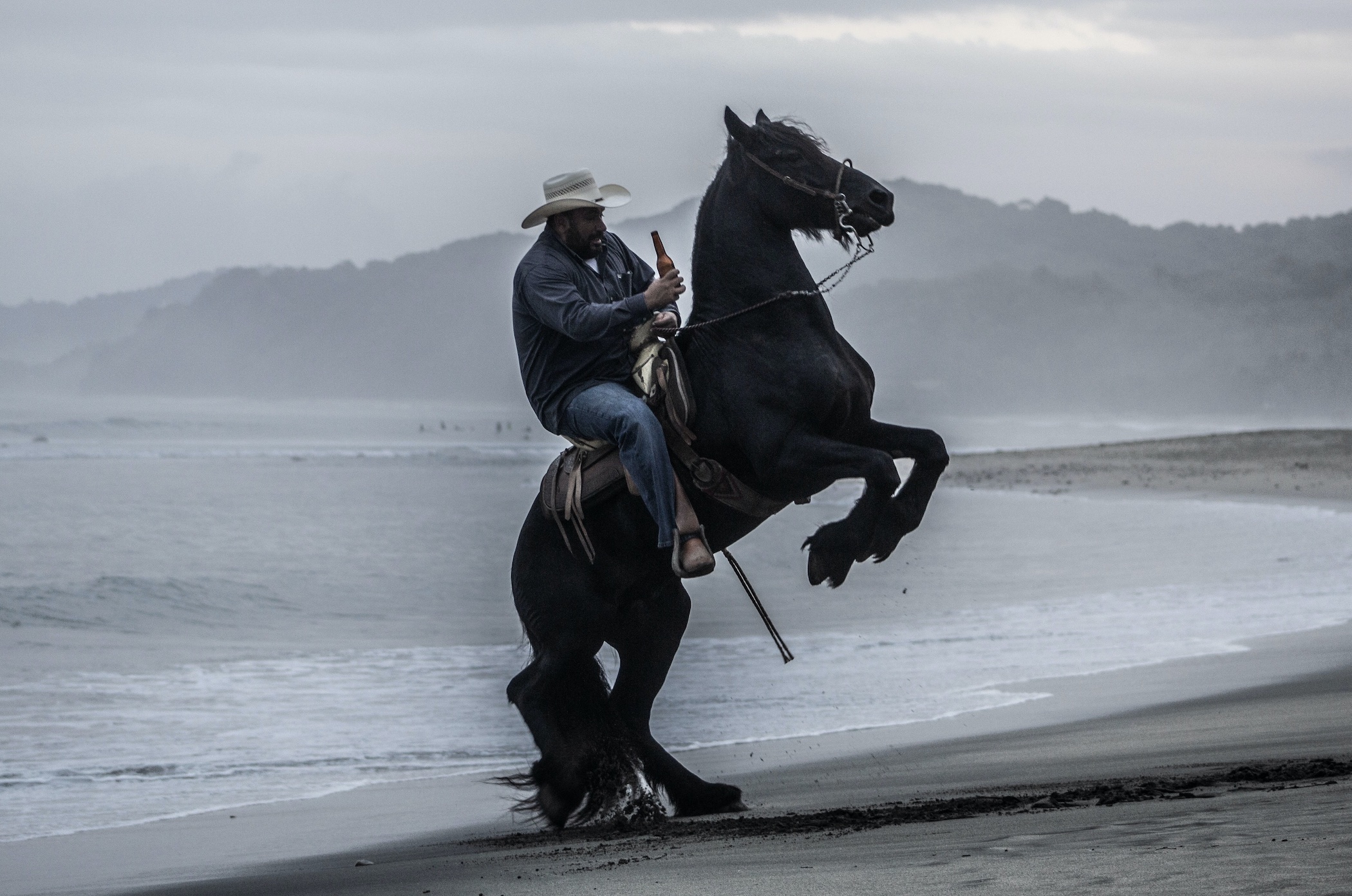 Man riding horse with beer bottle in hand; image by Antonio Piña, via Unsplash.com.