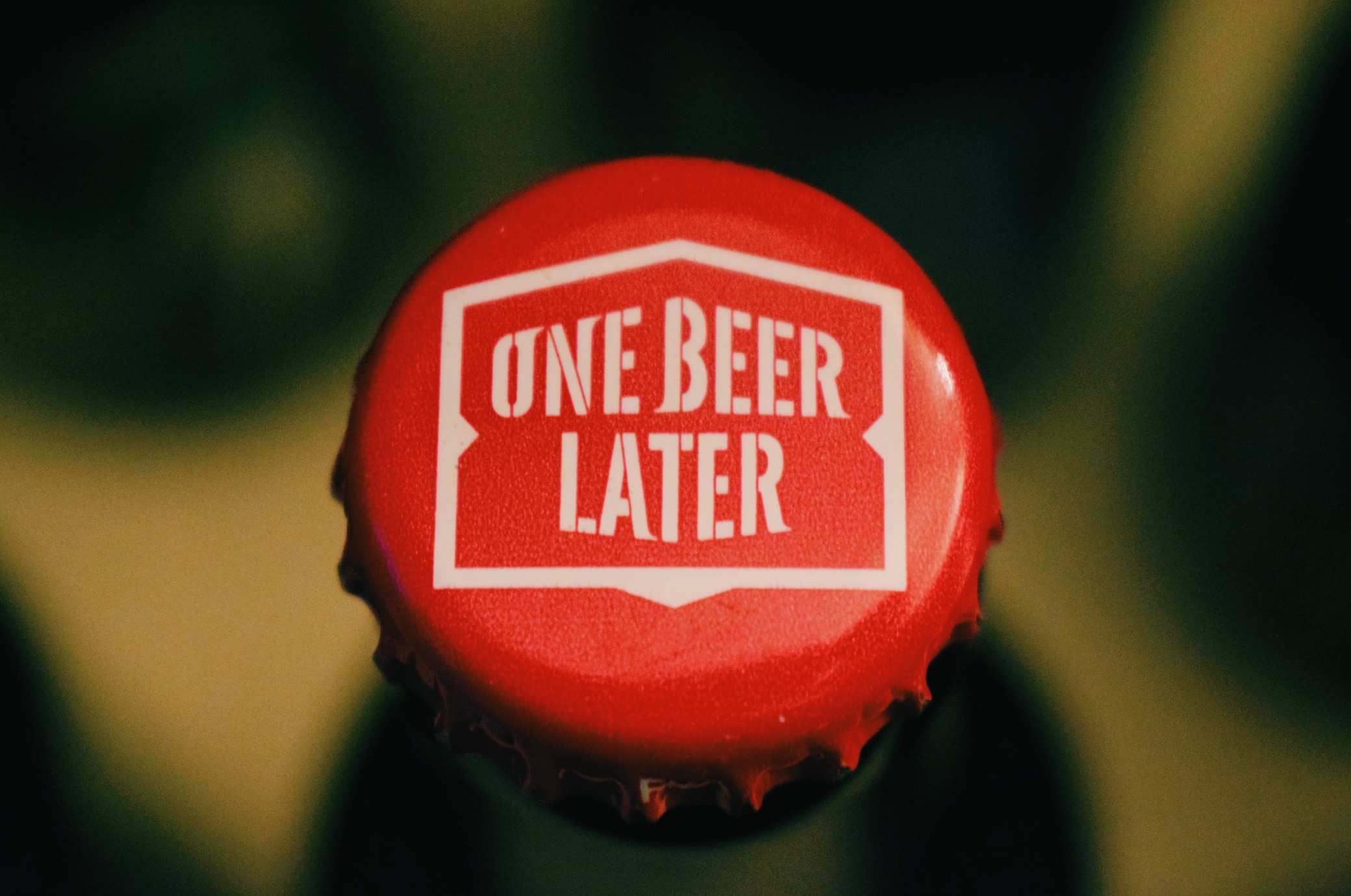 Upclose shot of beer bottle cap that says, One beer later; image by Stefan Cosma, via Unsplash.com.