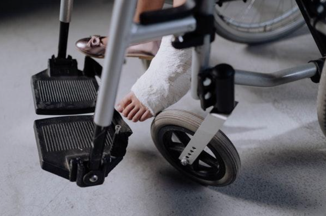 Woman in cast sitting in wheechair; image by Cottonbro, via Pexels.com.