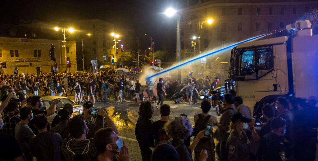 Water cannon used for crowd control in Jerusalem during the 2020 protests against Benjamin Netanyahu, with blue dye added to the stream. Or Barenholtz, CC BY-SA 3.0, via Wikimedia Commons.