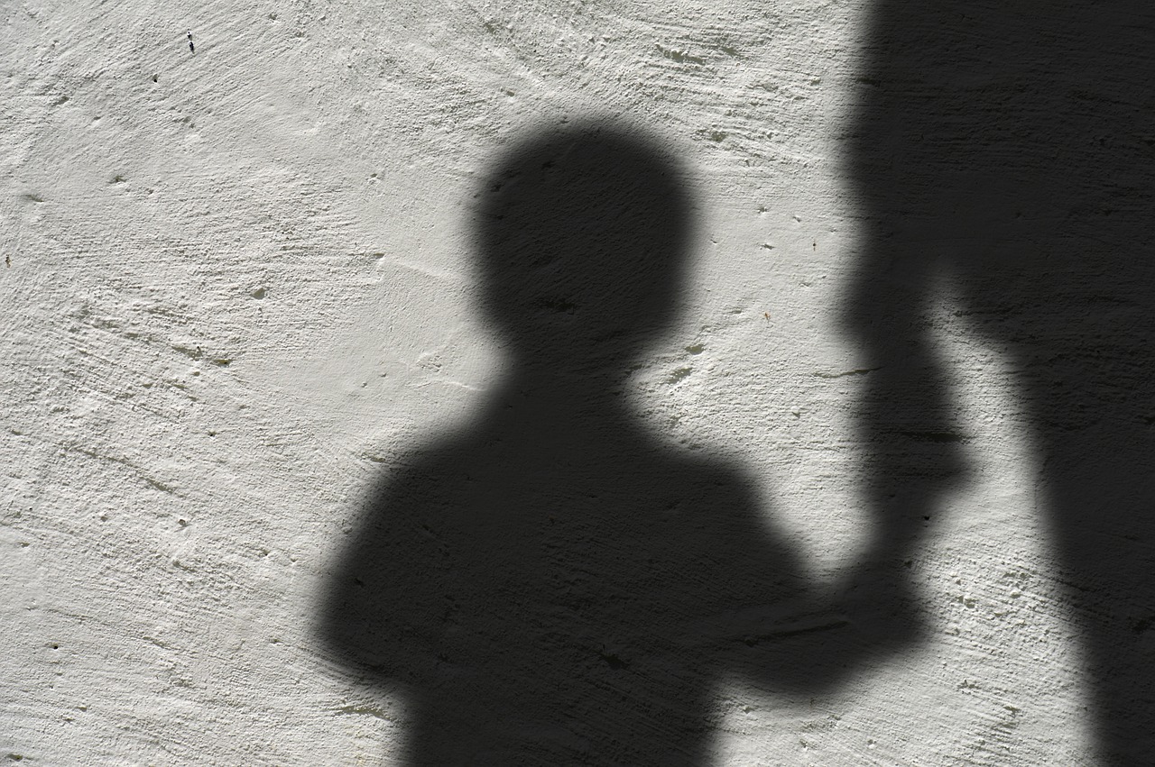 Silhouette of child and adult holding hands