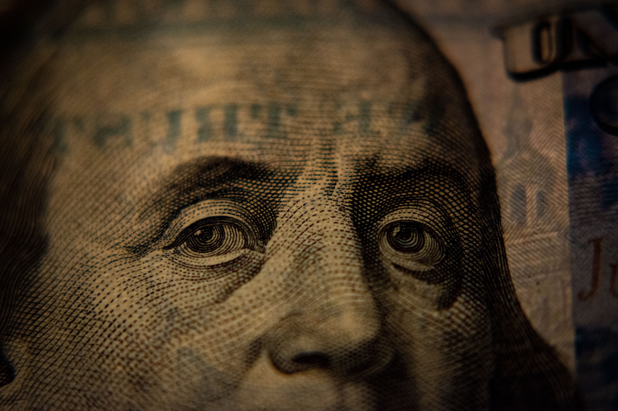 A closeup of a US hundred dollar bill (Benjamin Franklin side); image by Adam, via Unsplash.com.