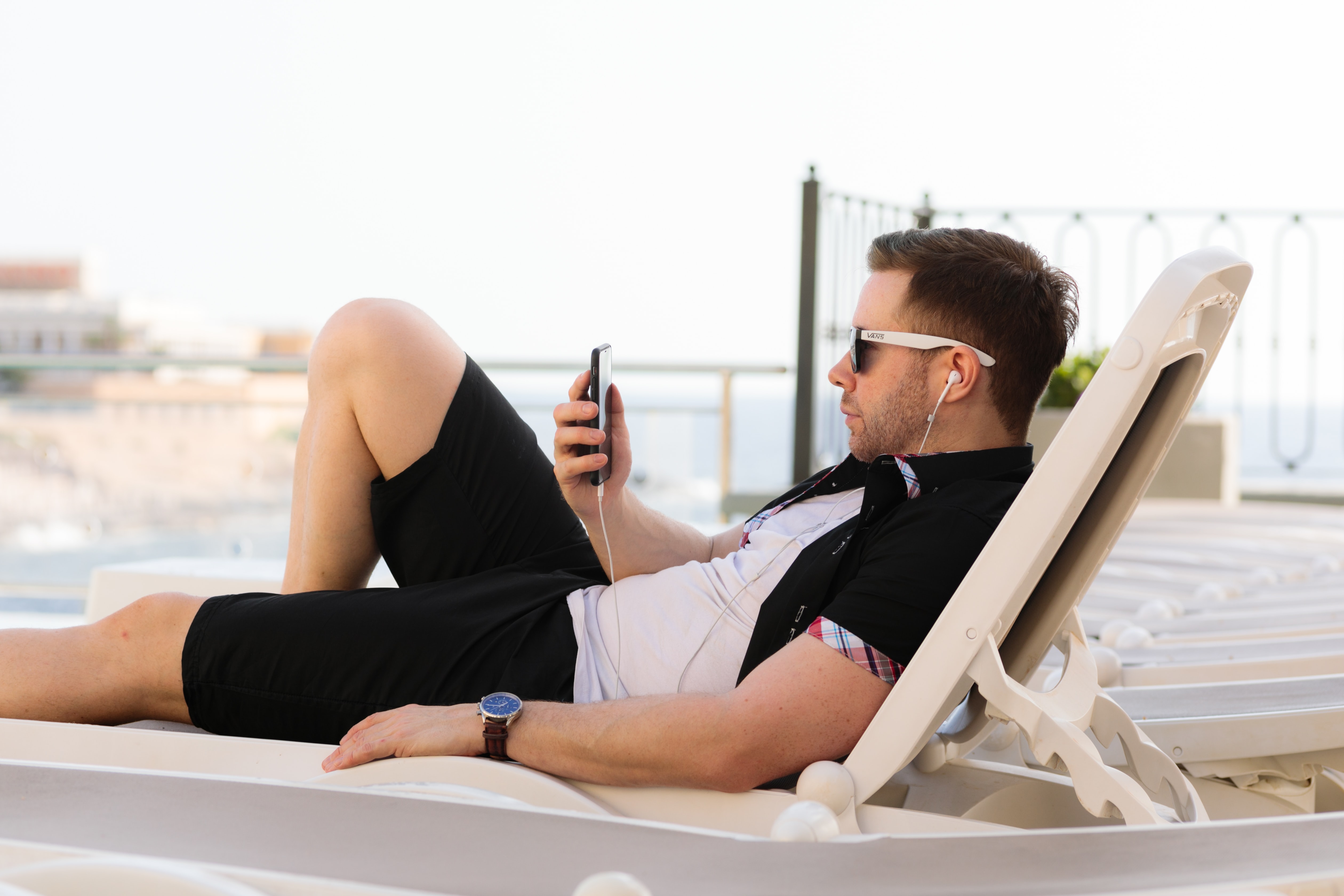 Man on sun lounger using smartphone; image by Humphrey Muleba, via Unsplash.com.