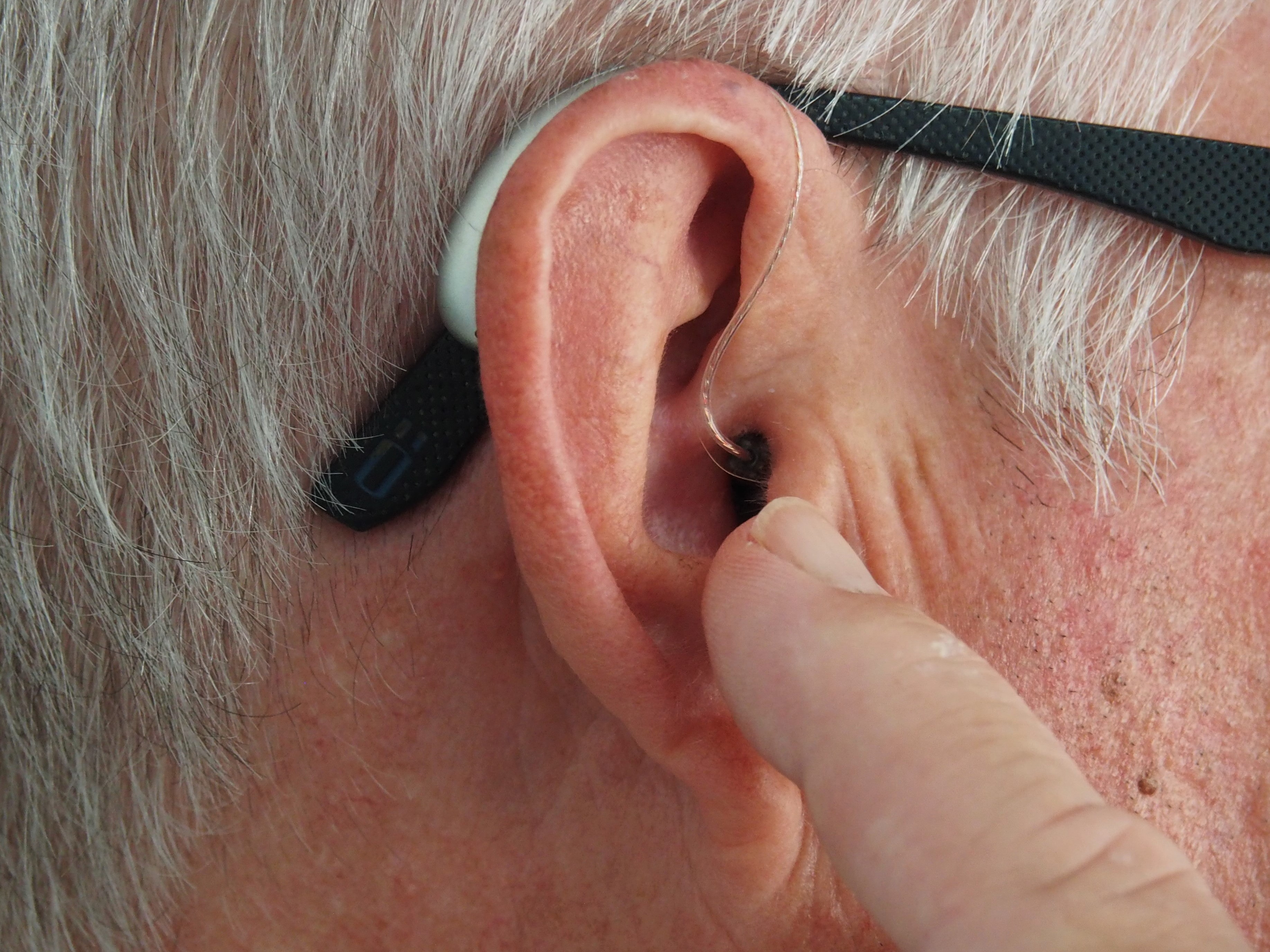 Person wearing hearing aid; image by Mark Paton, via Unsplash.com.
