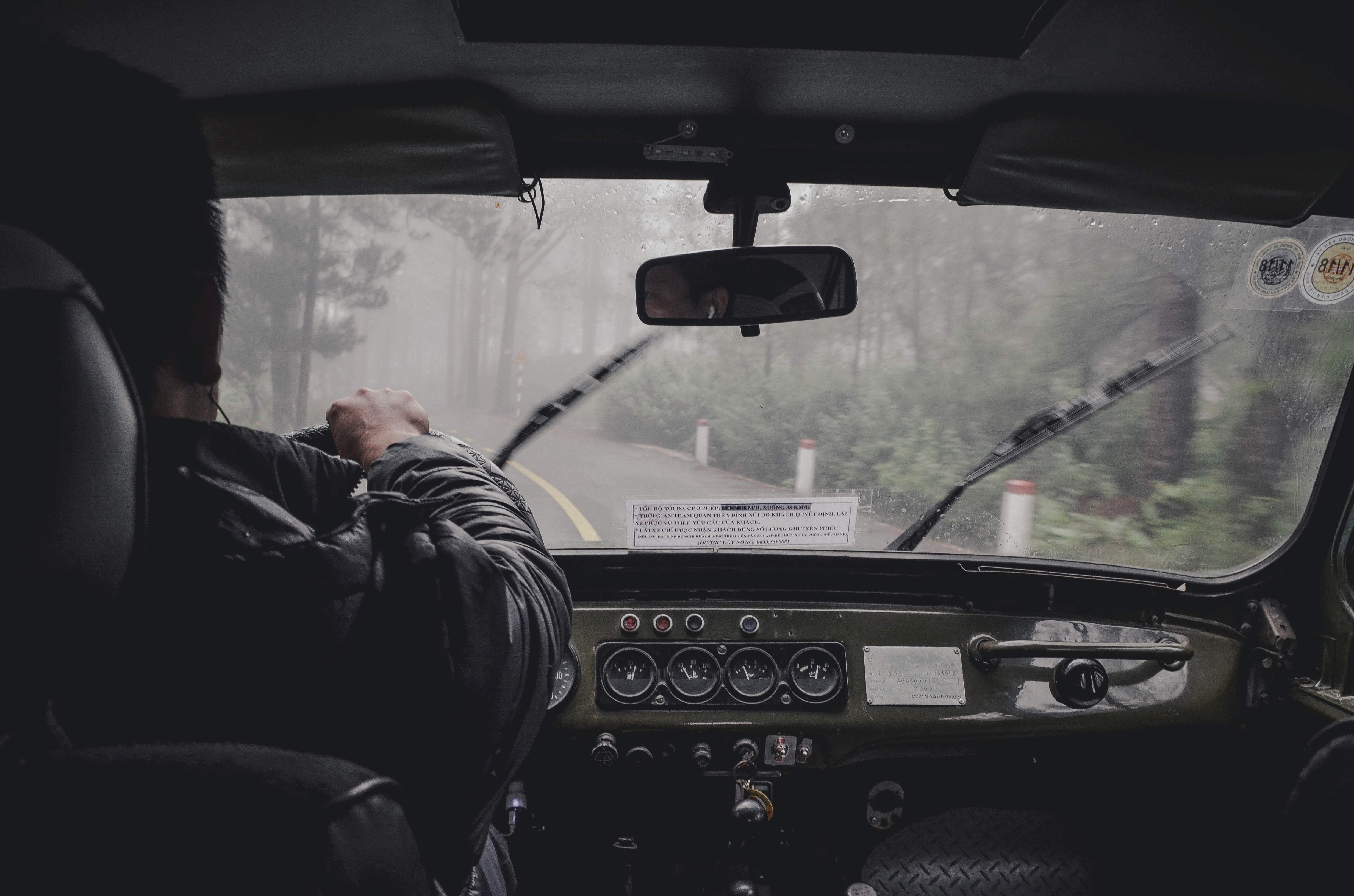 Truck driver inside cab; image by Thai An, via Unsplash.com.