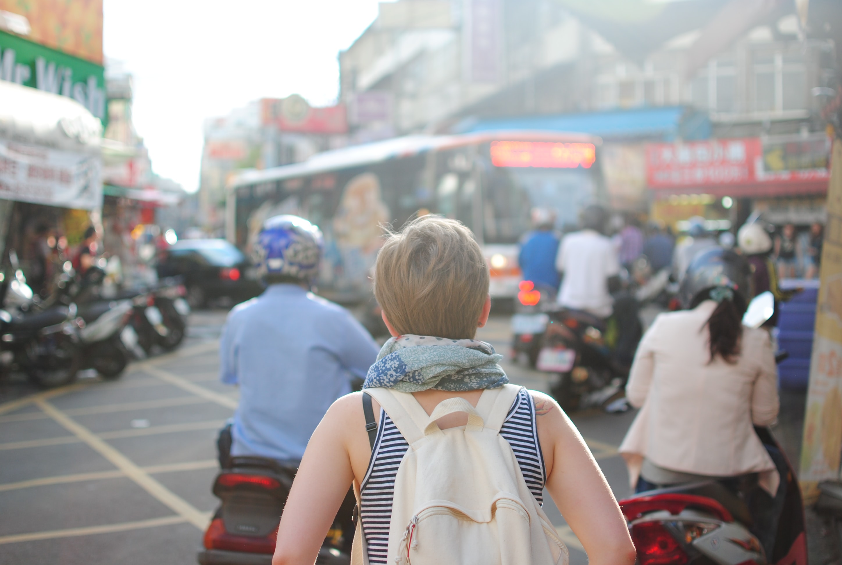 Woman backpacking in a busy city; image by Steven Lewis, via Unsplash.com.