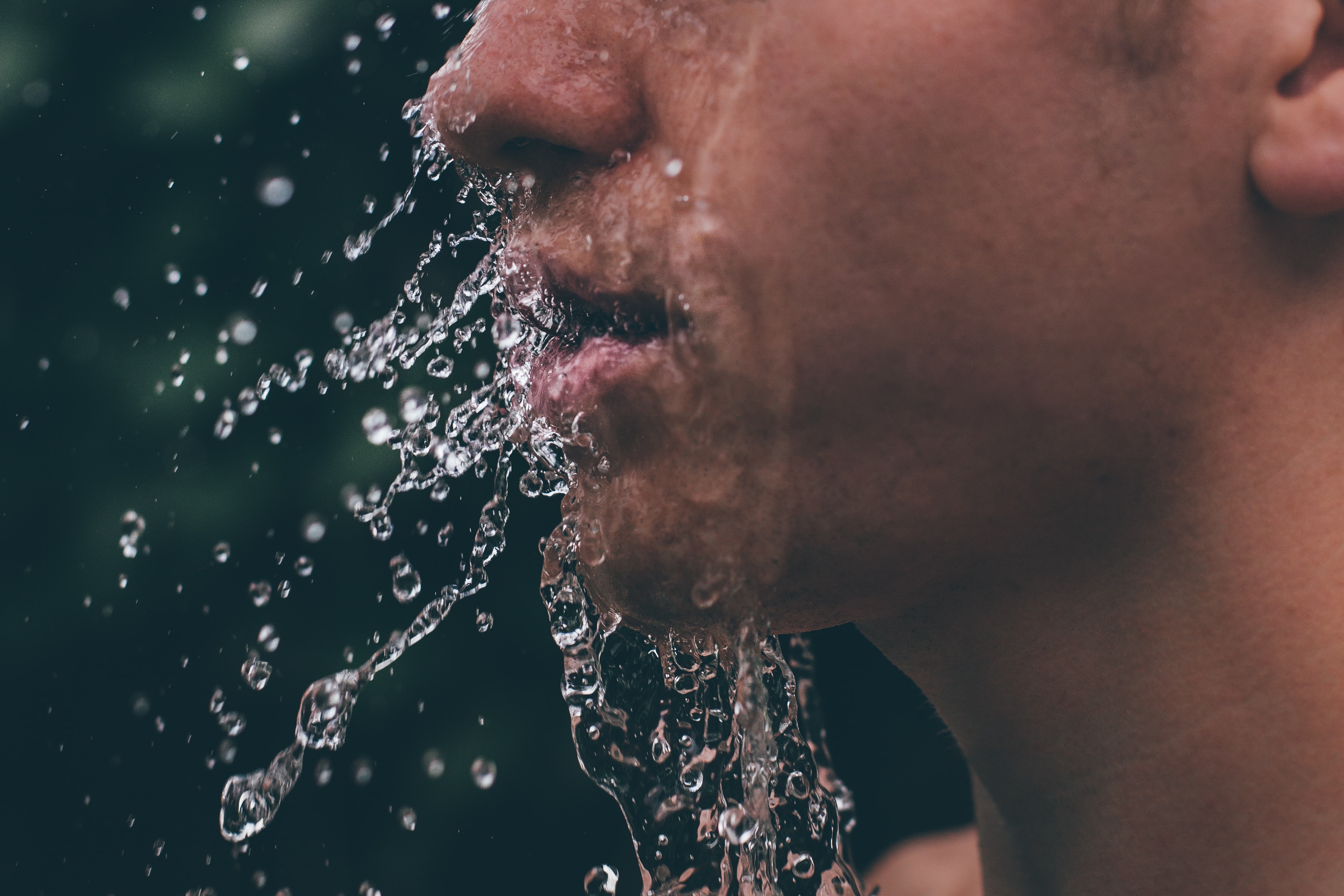 Man splashing water on his face; image by Lucas Sankey, via Unsplash.com.