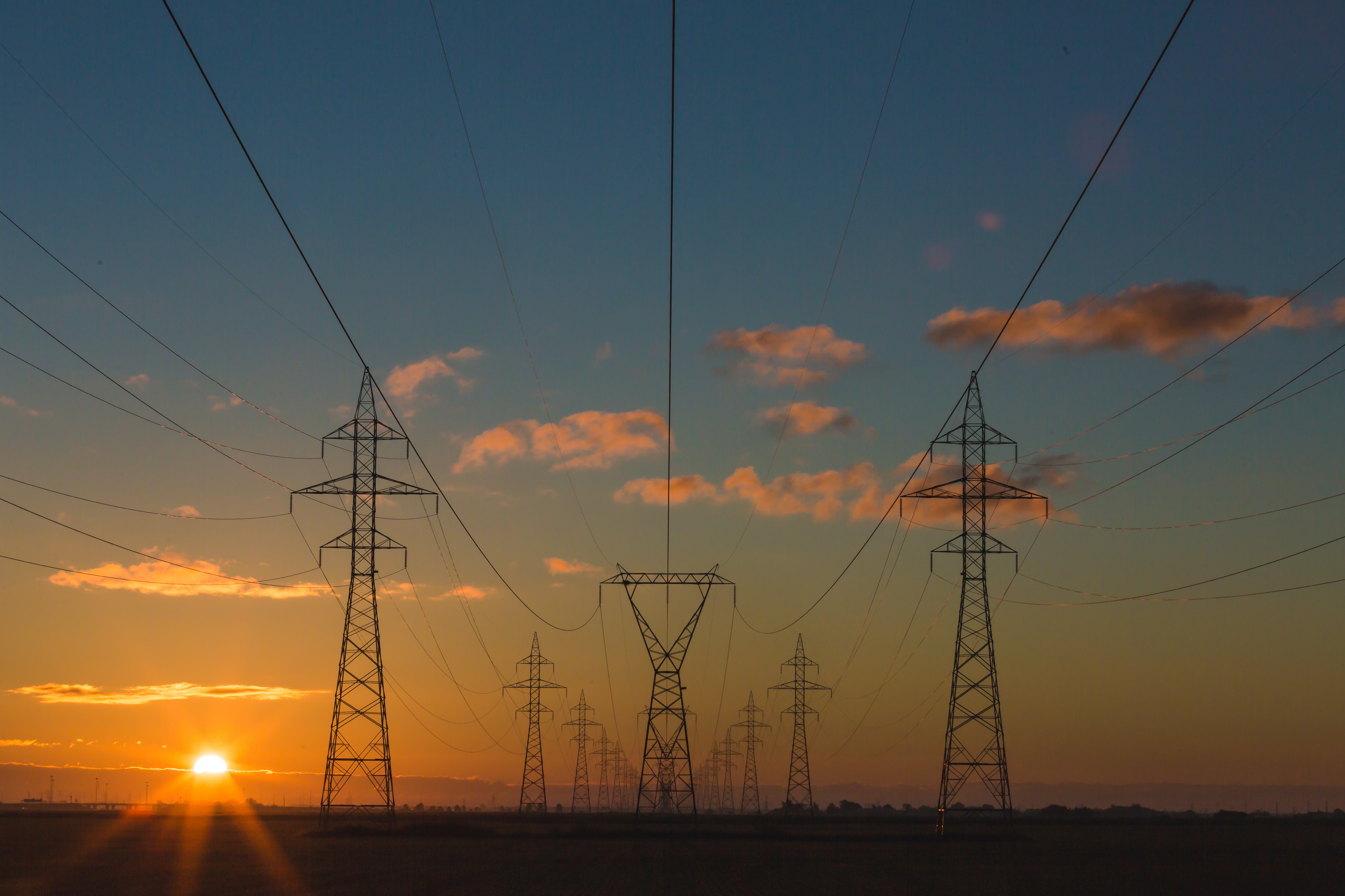 Power transmission lines at sunset; image by Matthew Henry, via Unsplash.com.