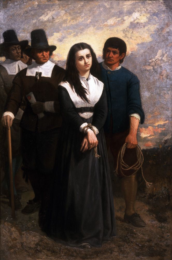 Pilgrim-dressed men regard a stoic woman whose hands have been tied.
