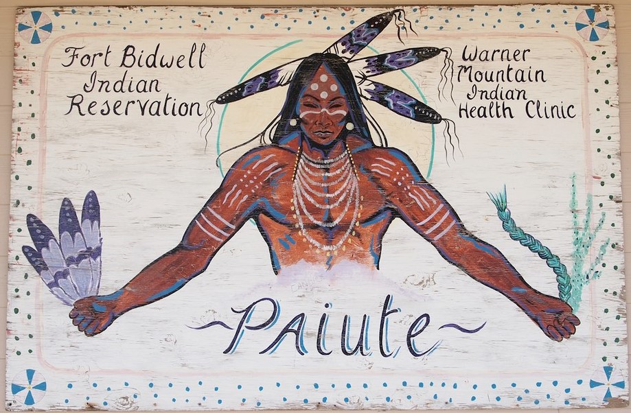 Painted art sign with a Native American figure wearing body paint, jewelry and feathers.