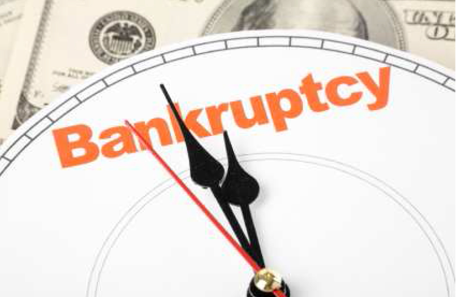 Clock sitting on money with "Bankruptcy" written on clock face in orange letters; image by Alachua County, via Flickr.com, CC BY 2.0.