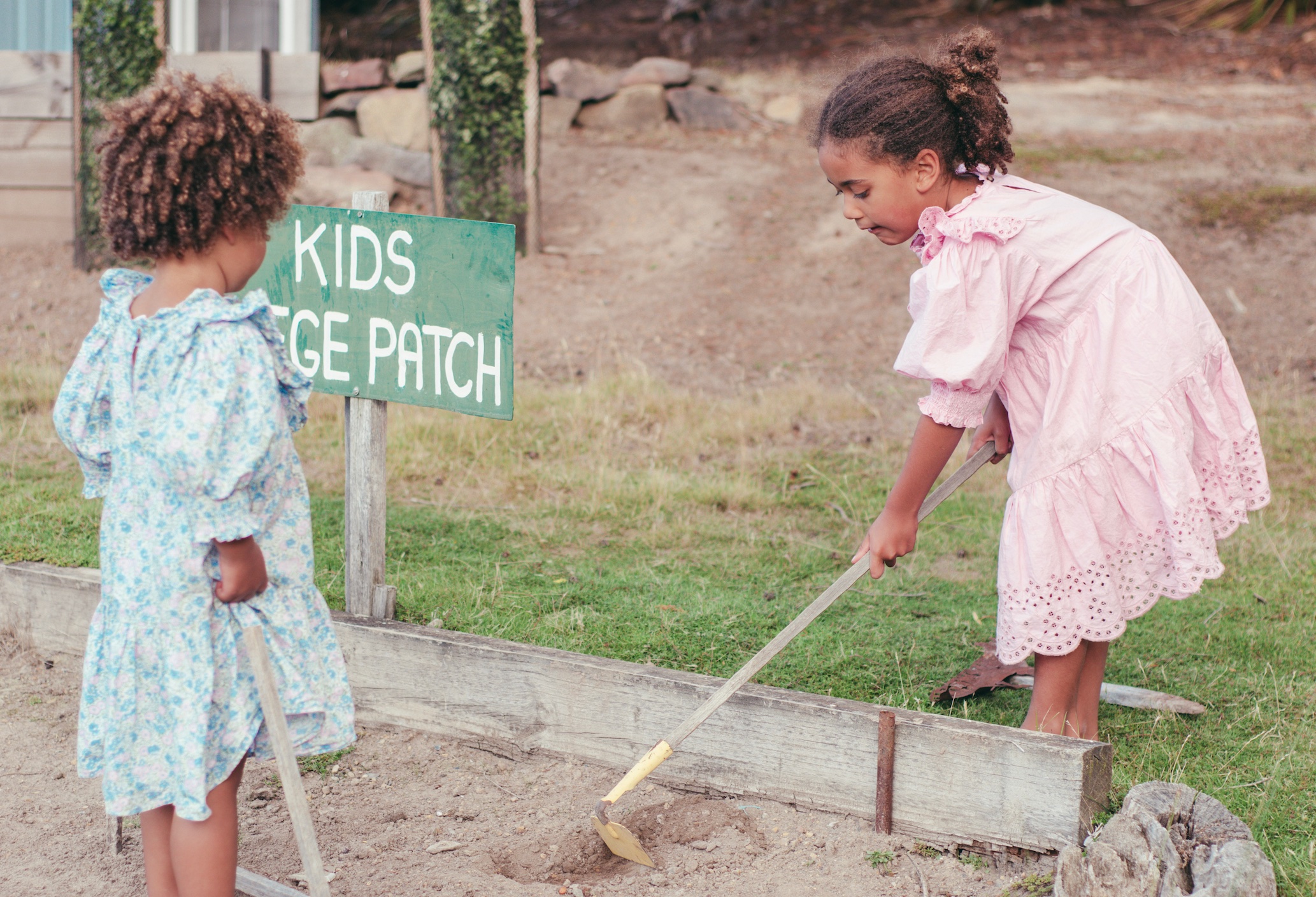 Two little girls tending a kids garden patch; image by Mieke Campbell, via Unsplash.com.