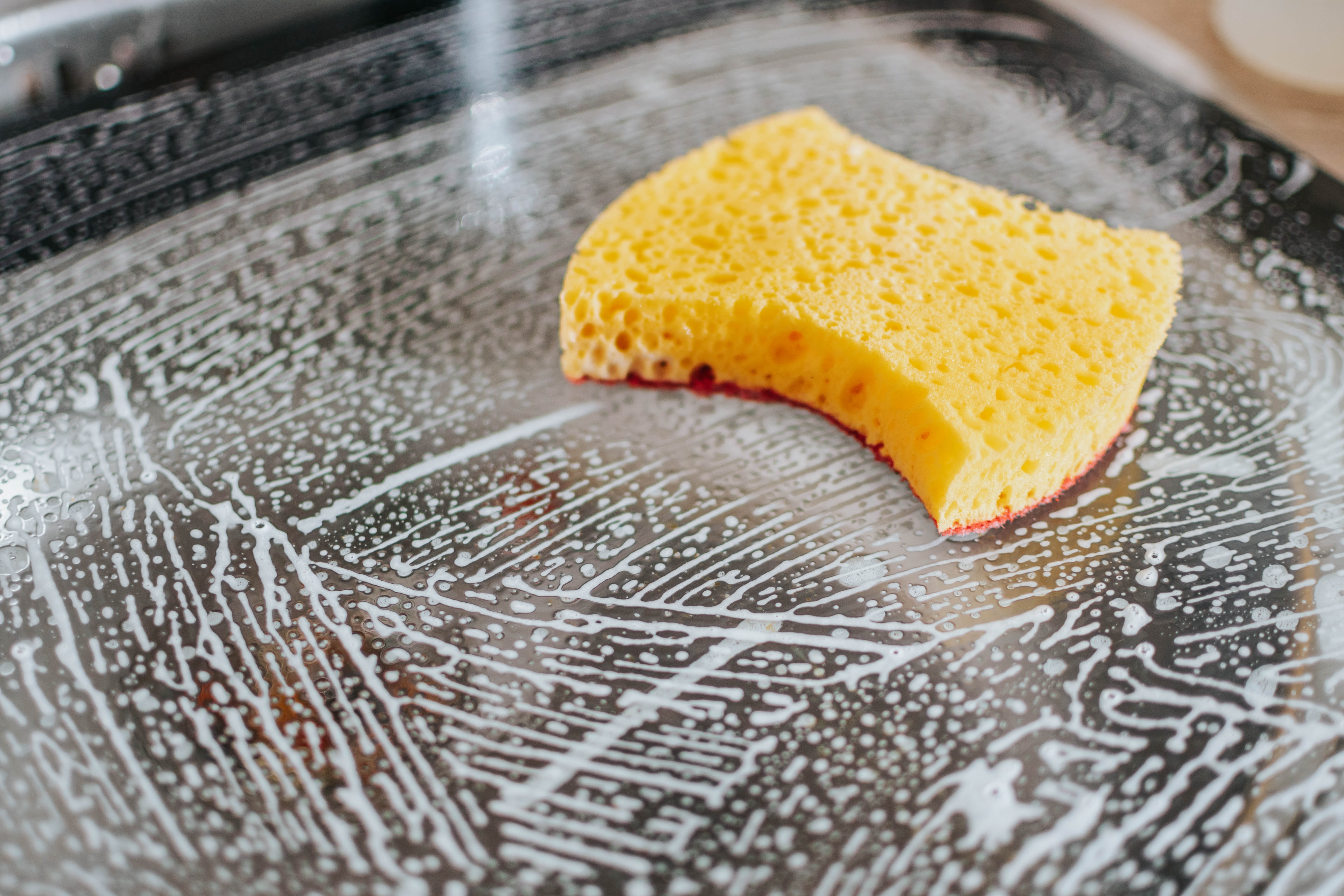 Sponge and soap on glass surface; image by Pille R. Priske, via Unsplash.com.